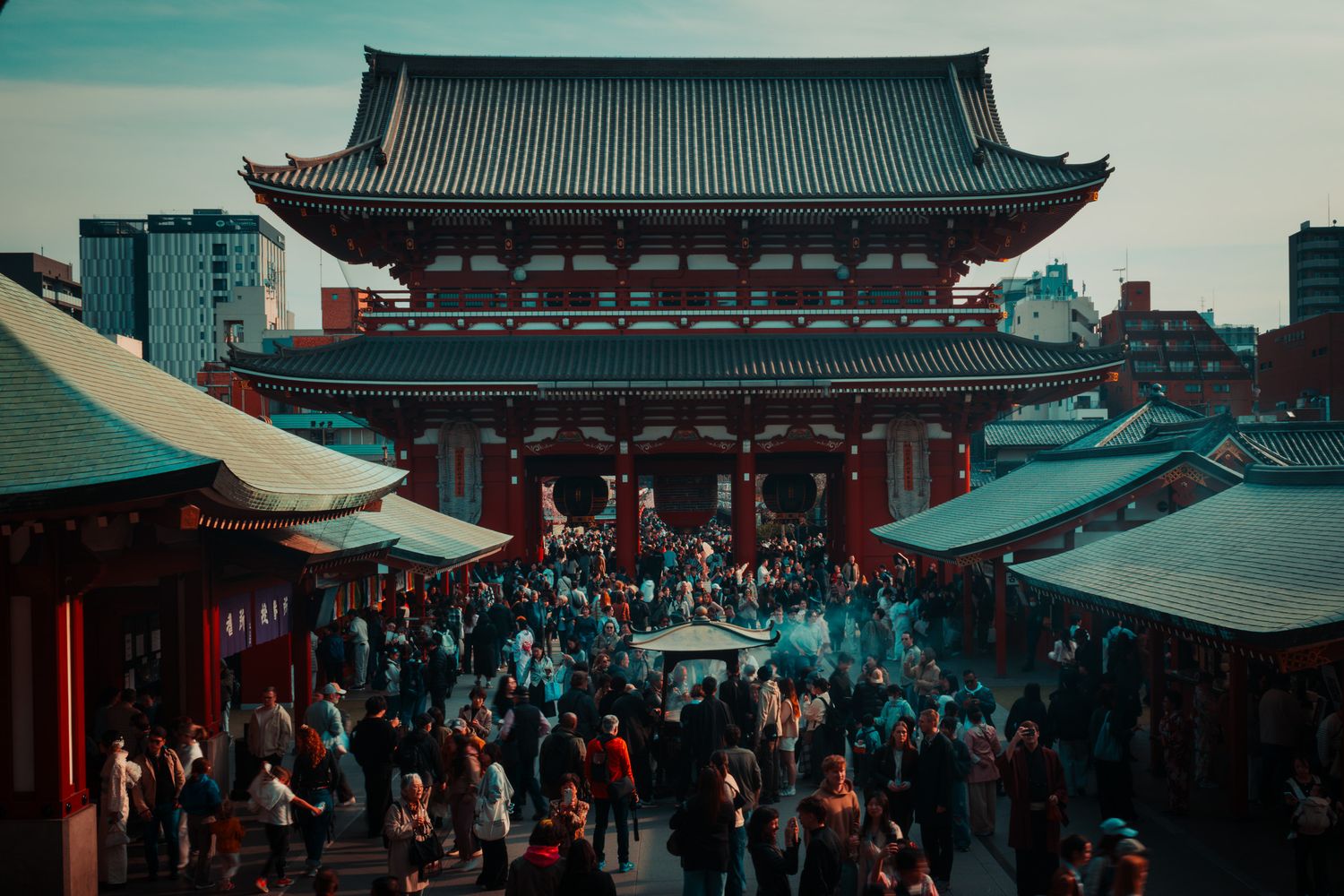 Crowds gather at Senso-ji Temple in Asakusa, Tokyo, Japan, with the iconic Hozomon gate in the background.