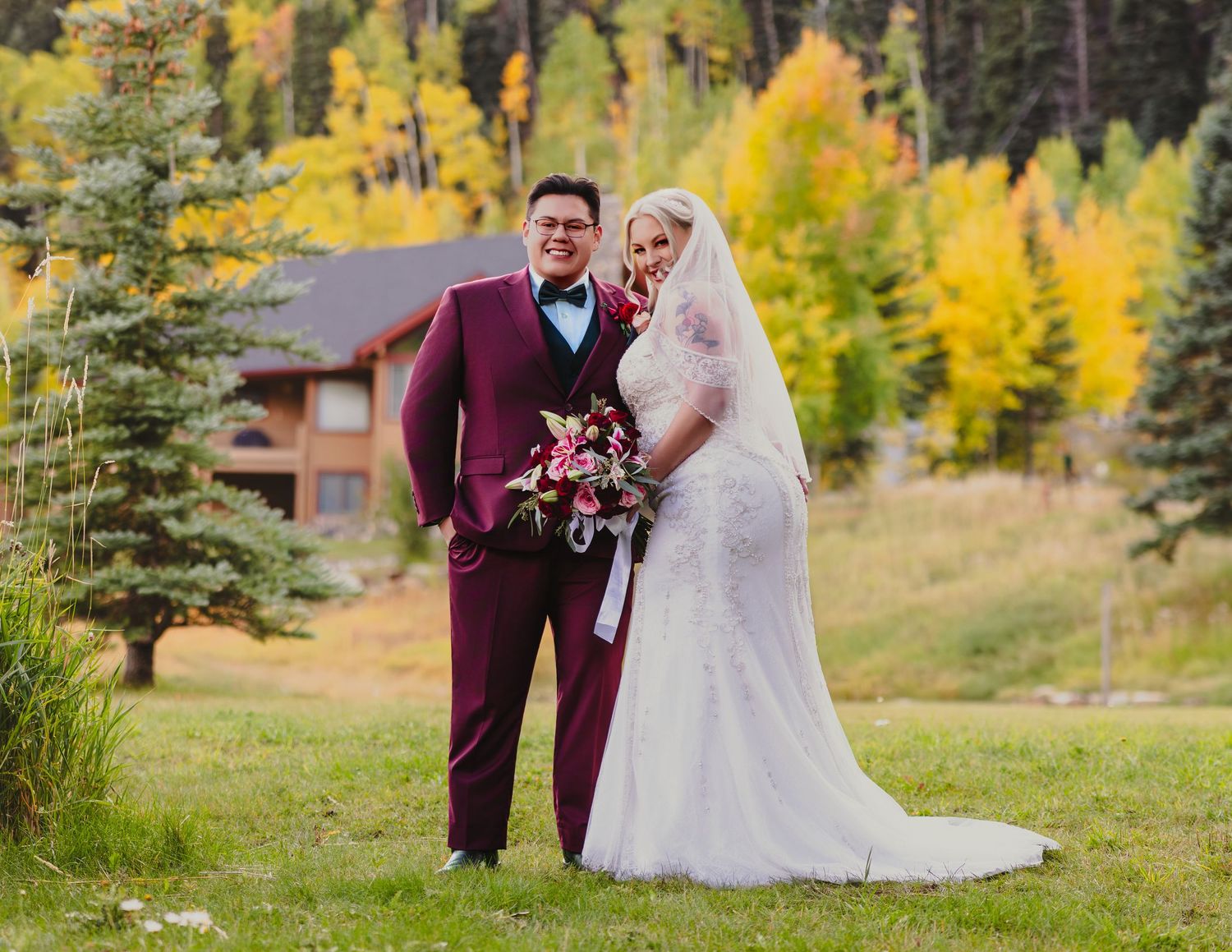 Bride and groom posing outdoors among vibrant fall foliage in Colorado mountain wedding.
