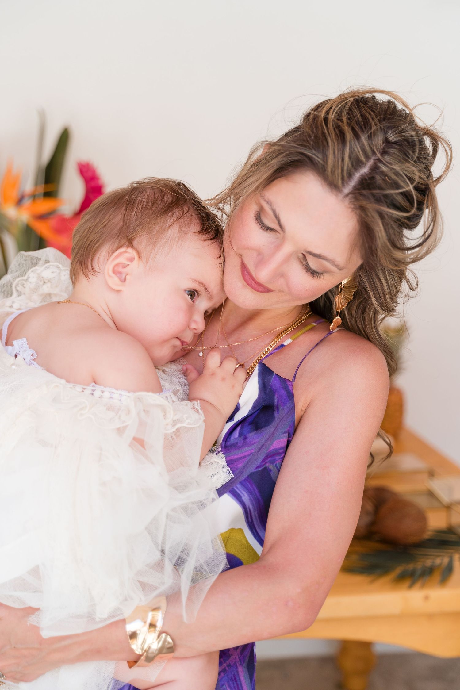 A sweet family moment captured with snuggles and embraces on a wooden floor.