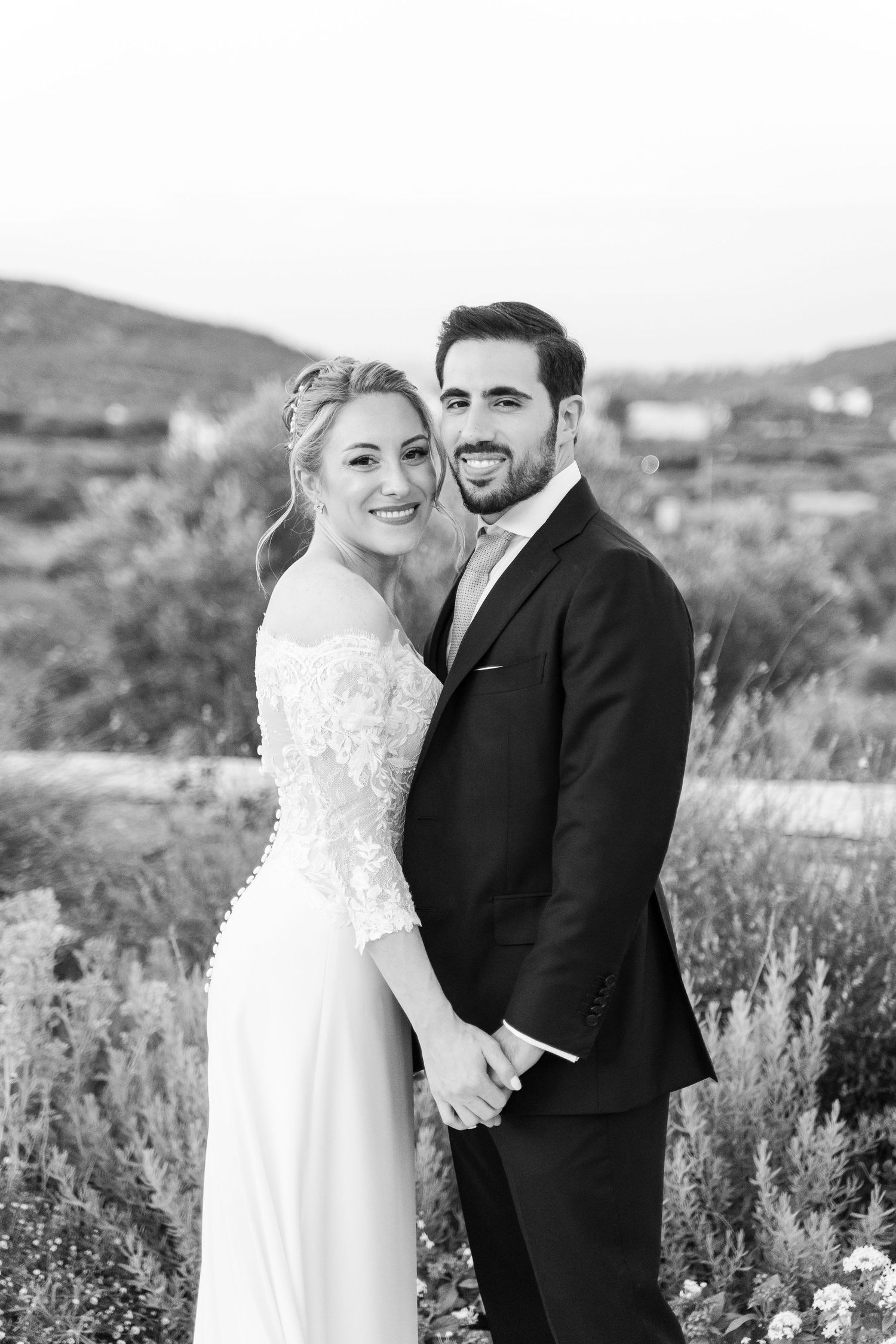 Black and white portrait of a happy wedding couple in an outdoor setting.