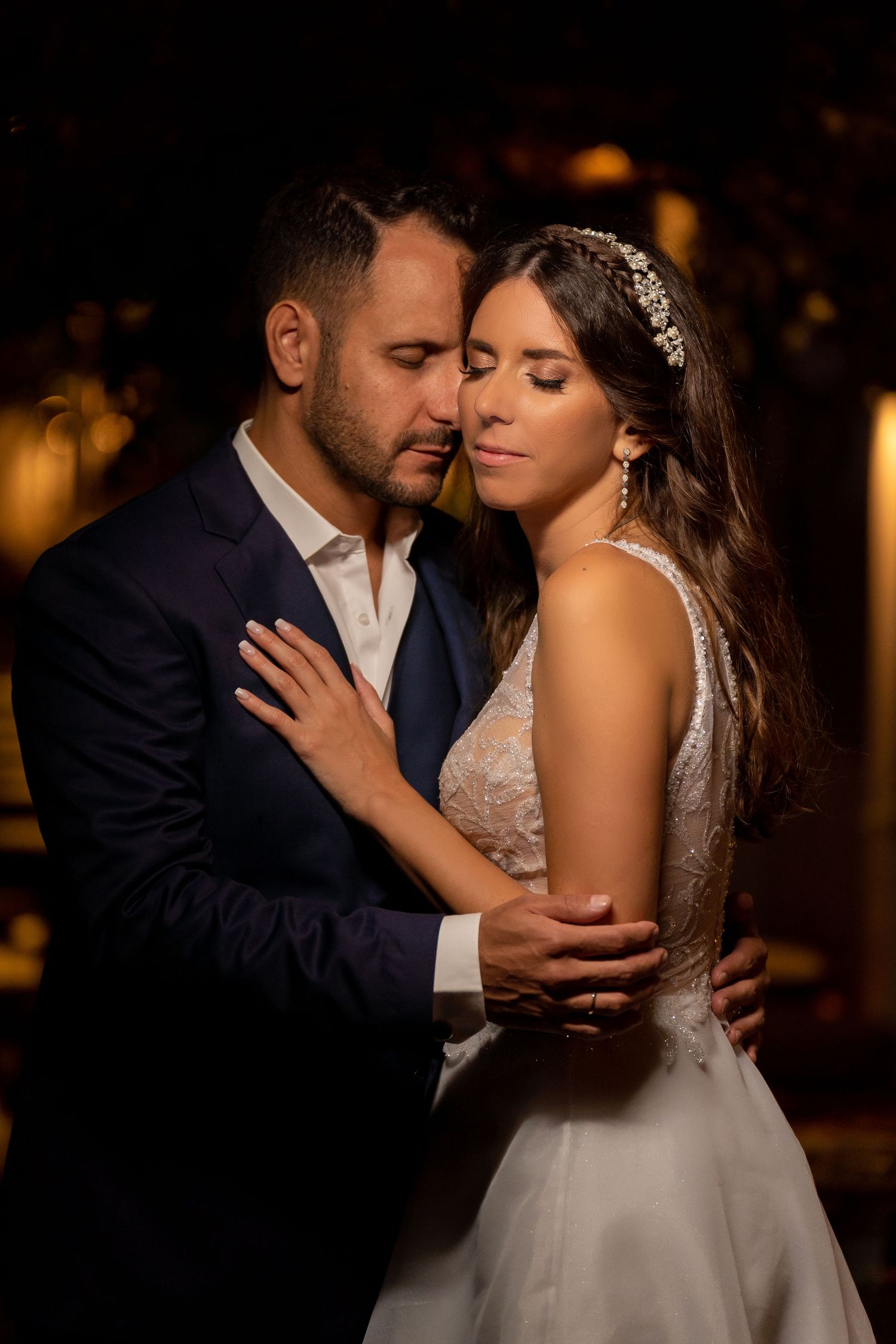 A romantic wedding couple shares intimate moments together in a series of dimly lit evening portraits.