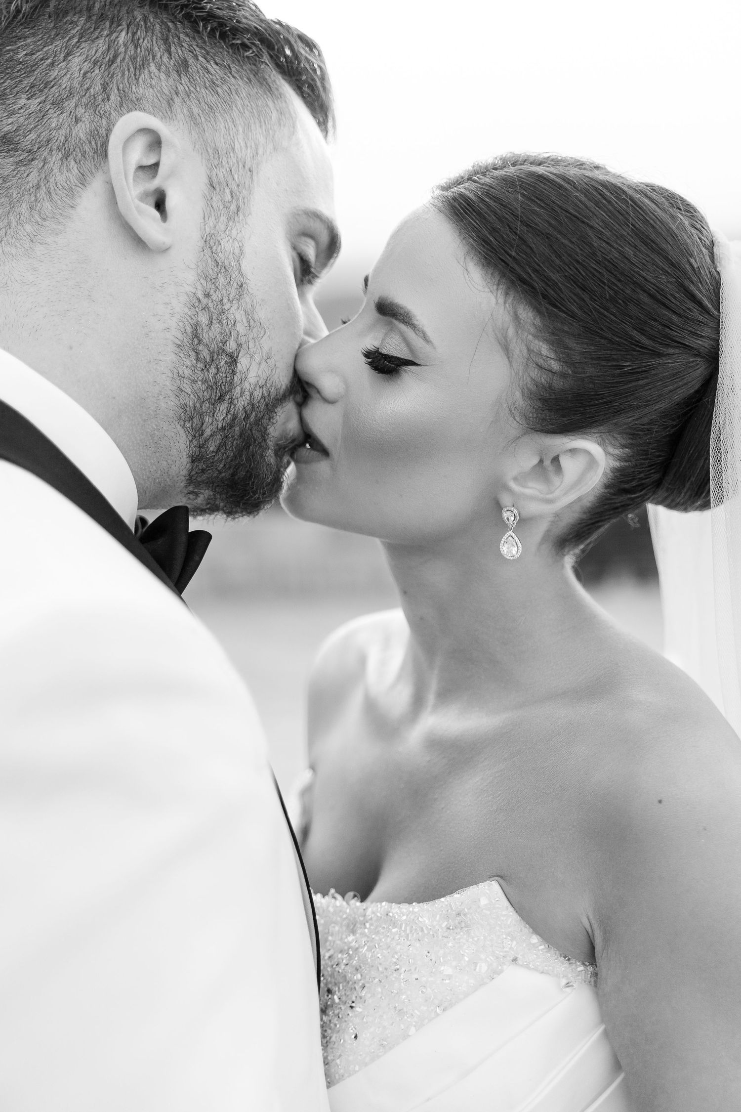 Intimate black and white close-up of wedding kiss.