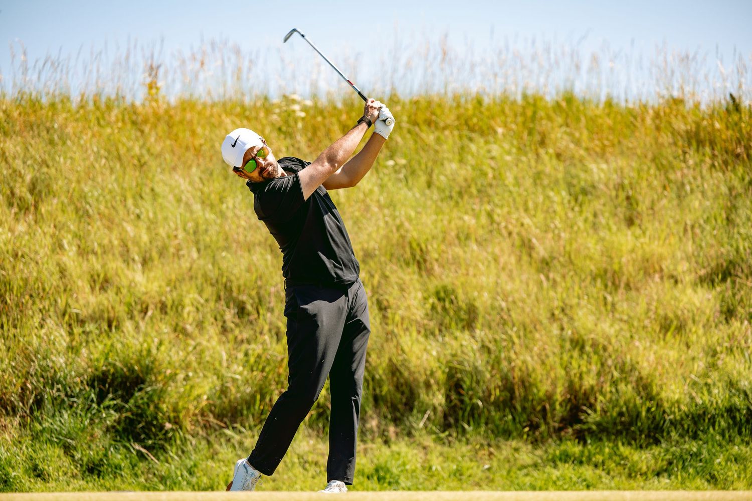 Golfer in action after playing a big shot at Kingsbarns Links.