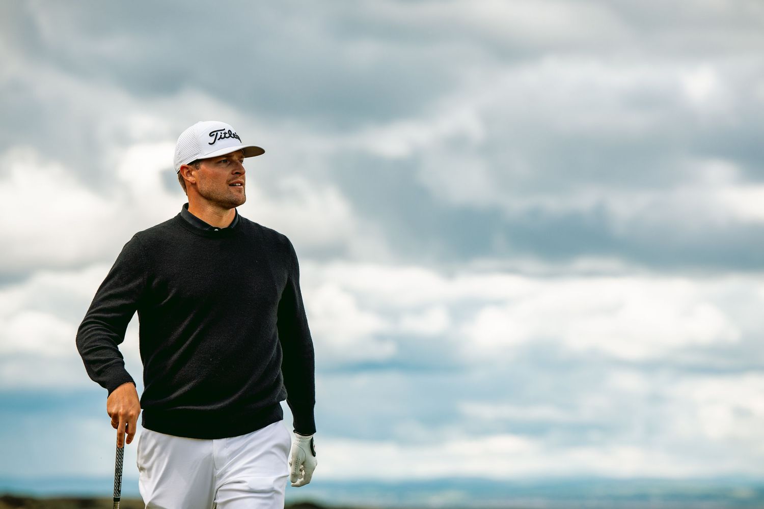 Golfer walking in action with golf club in hand