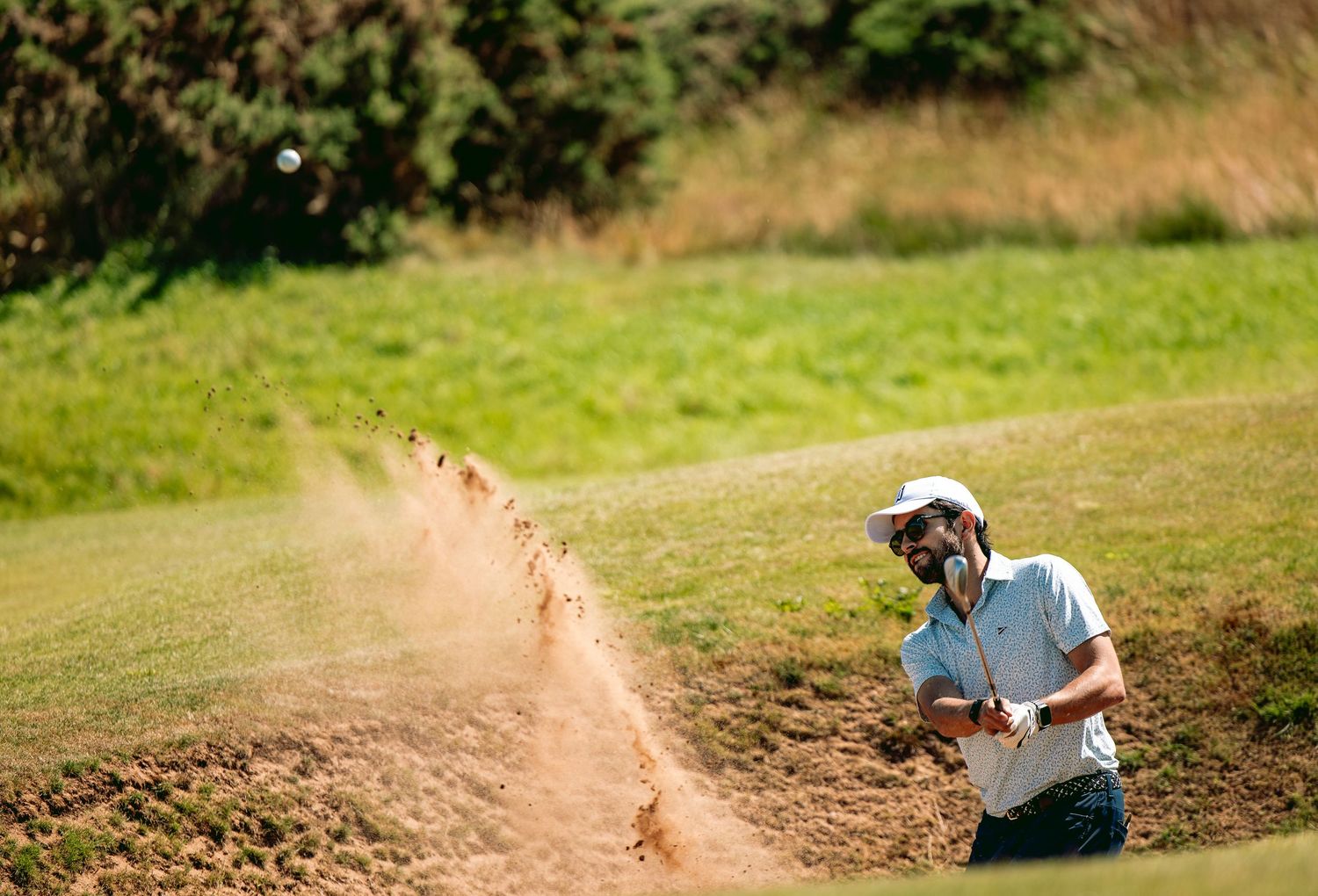 A golfer played a shot from bunker at Kingsbarns Links causing divot.