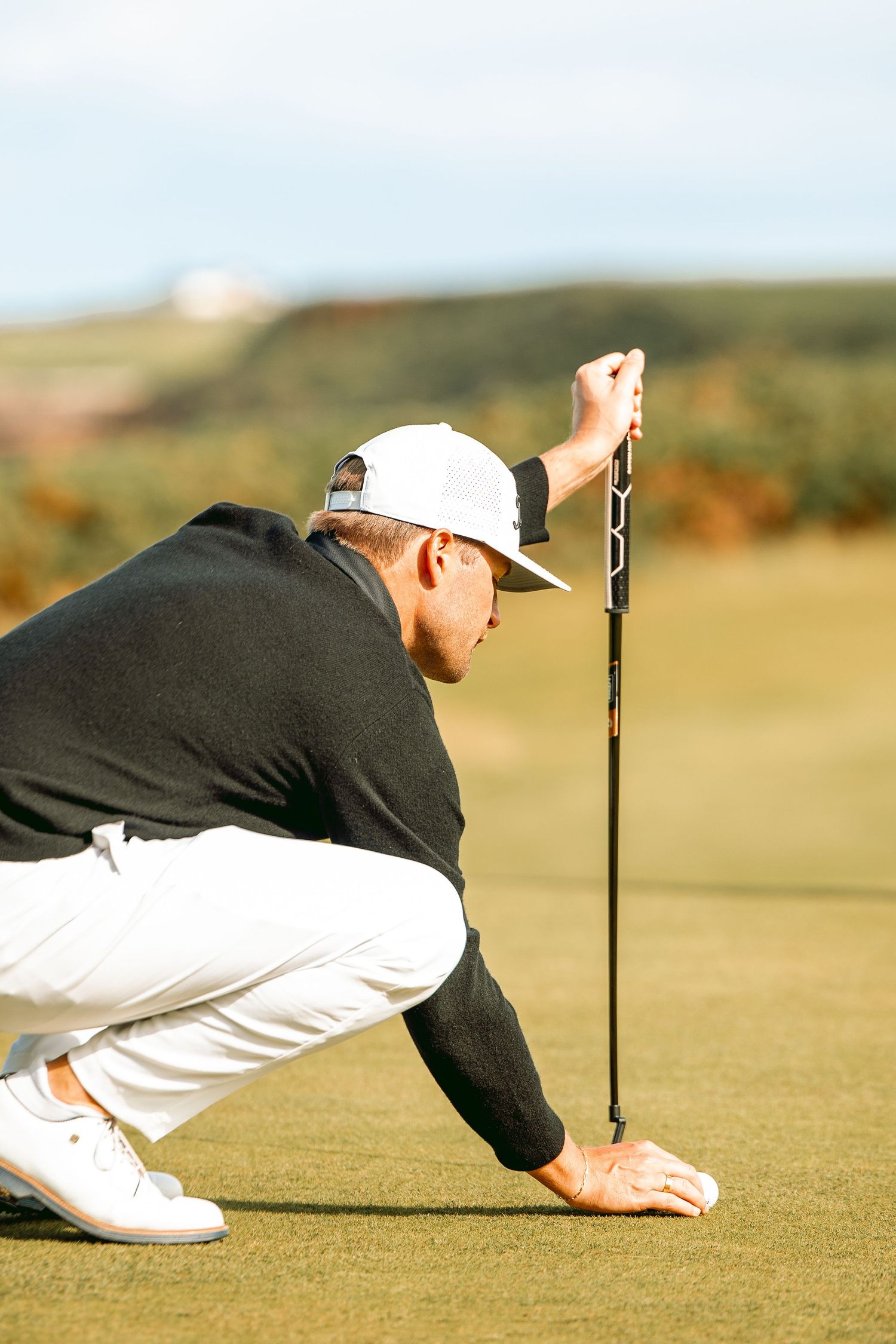 Golfer in sitting postion doing ball placement before shot