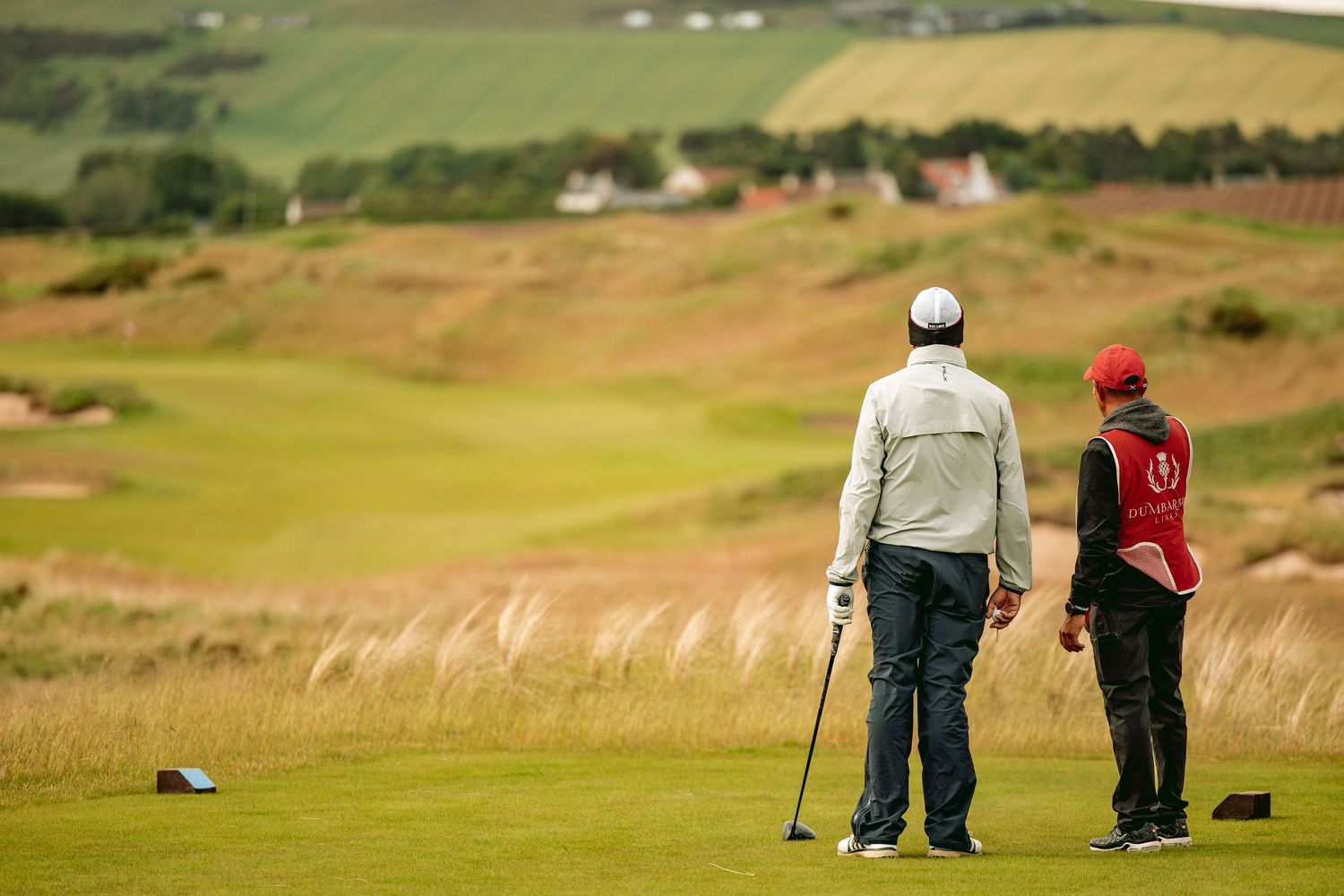Two golfers standing and discussing to play the next shot at Dumbarnie Golf Links.