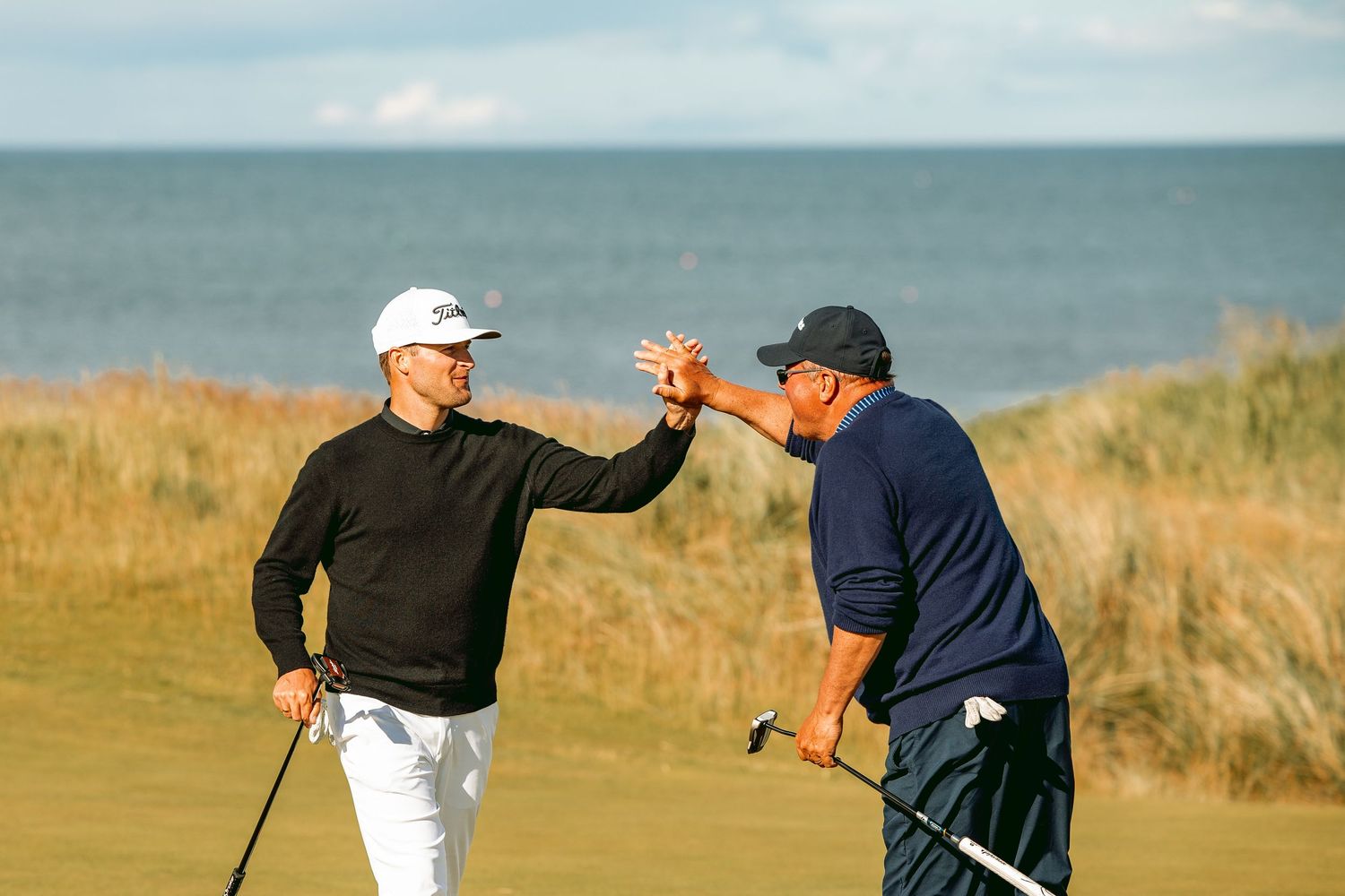 Excited golfers doing hi-five at kingsbarns golf course