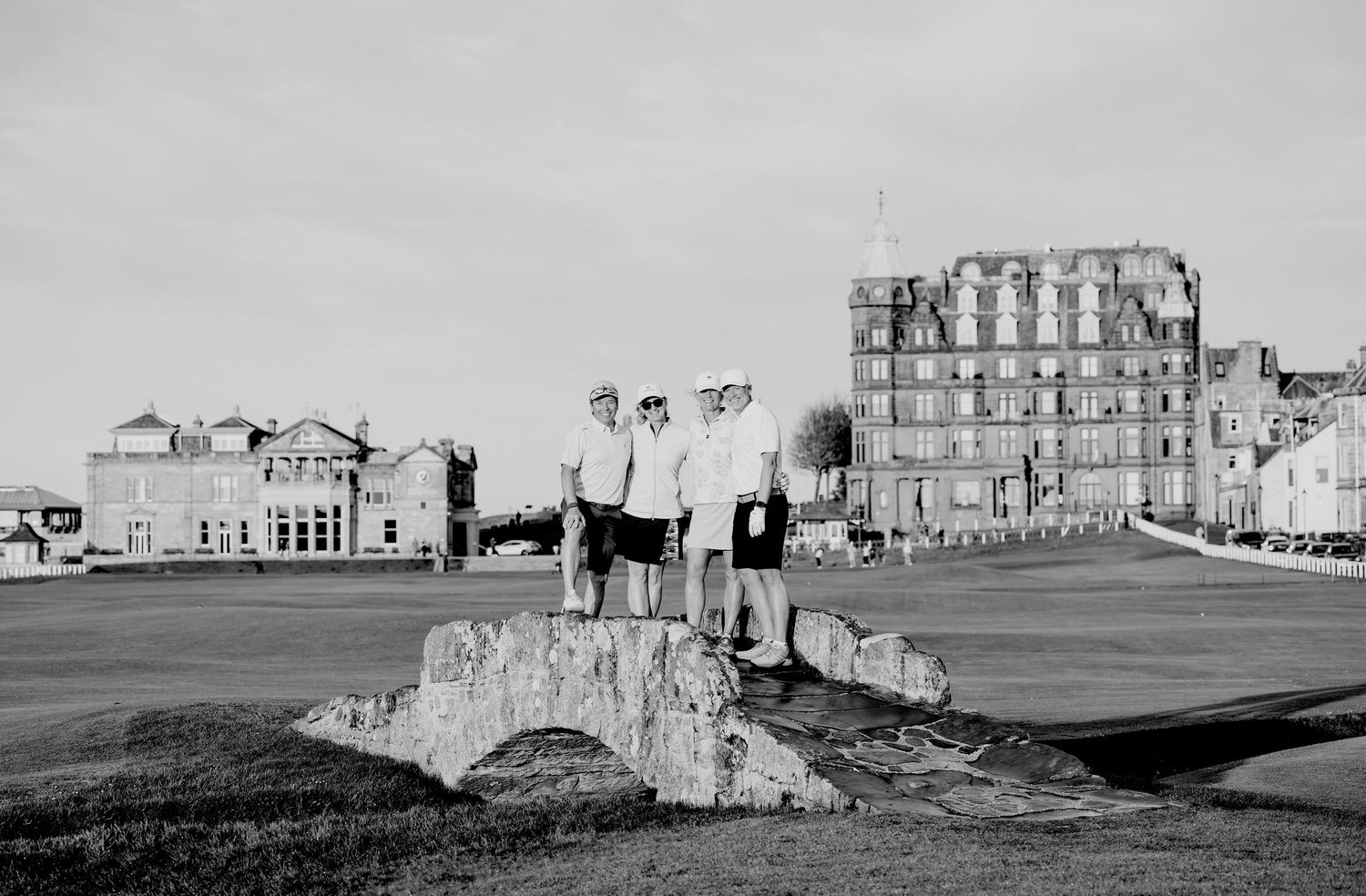A group of golfers standing on Swalcon Bridge at Old Course.