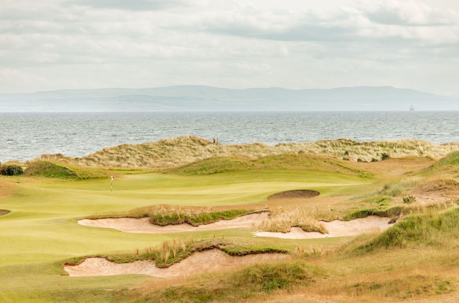 A panoramic view of Dumbarnie Links with sandy dunes and bunkers.