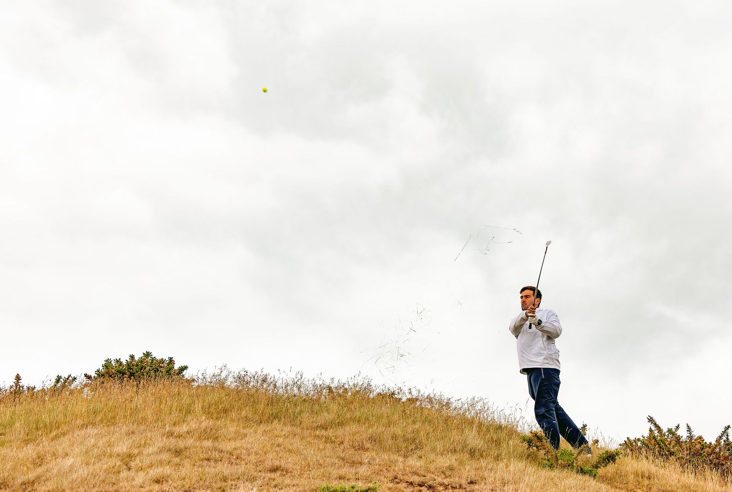 Photo of a golfer from side right after playing a shot at Dumbarnie Golf Links.