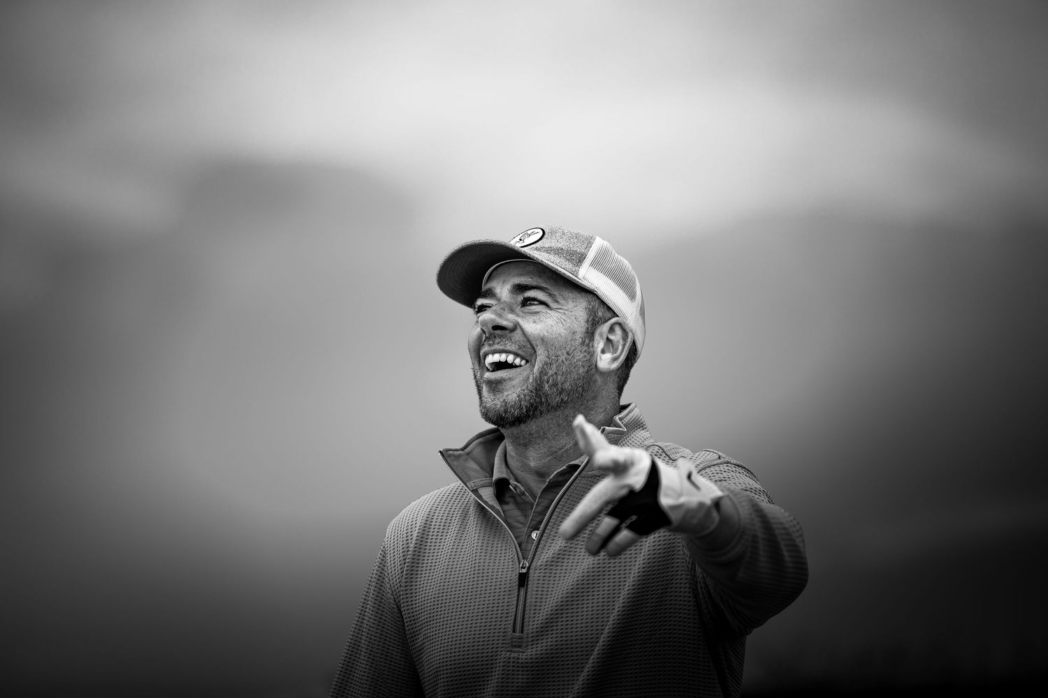 Man laughing and pointing in the ball's direction, playing at Canoustie Links.