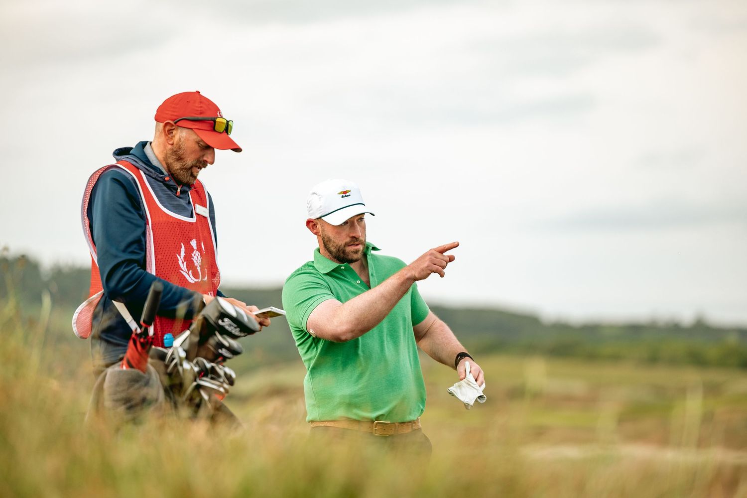 Two golfers discuss their game while standing at Dumbarnie Links.