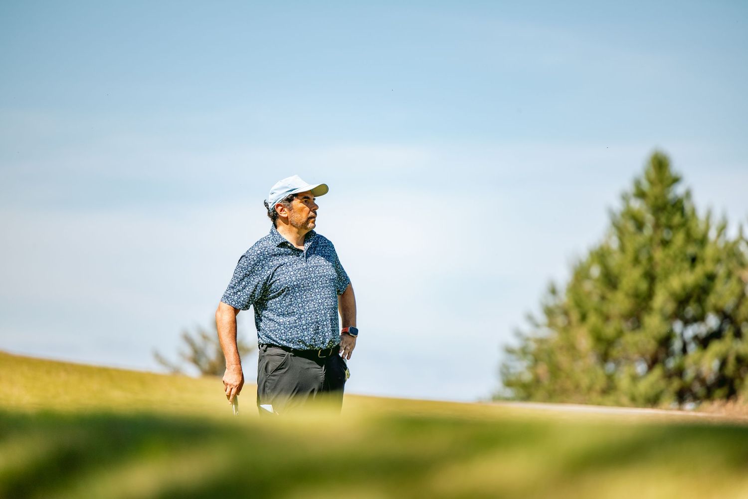 Man with golf club standing at Kingsbarns Links.