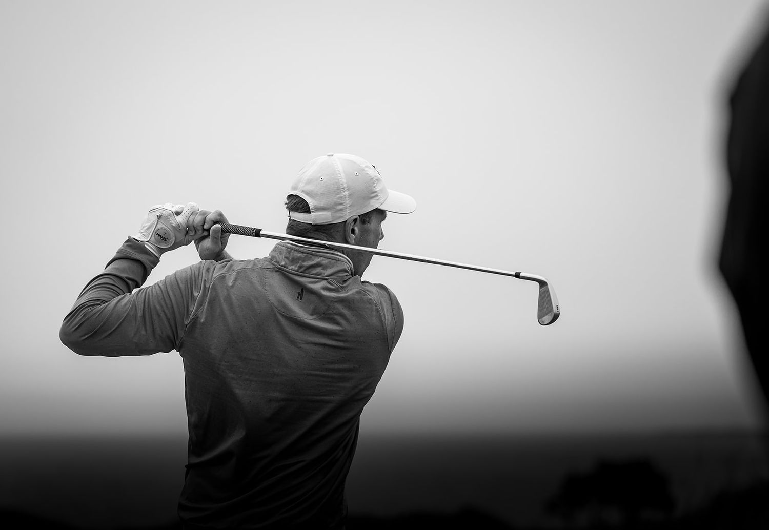 Golfer in action with club in air after playing a perfect shot at Kingsbarns Links