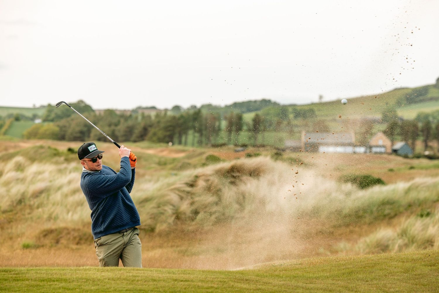 Golfer swings golf club in style while playing at Dumbarnie Links.
