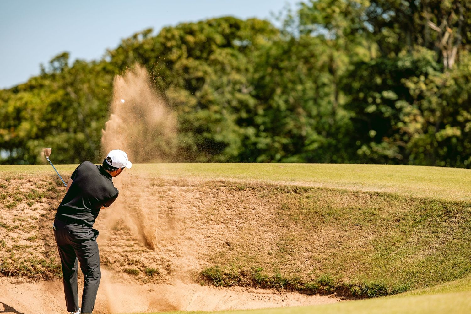 A golfer played a slow shot from bunker at Kingsbarns Links causing divot.