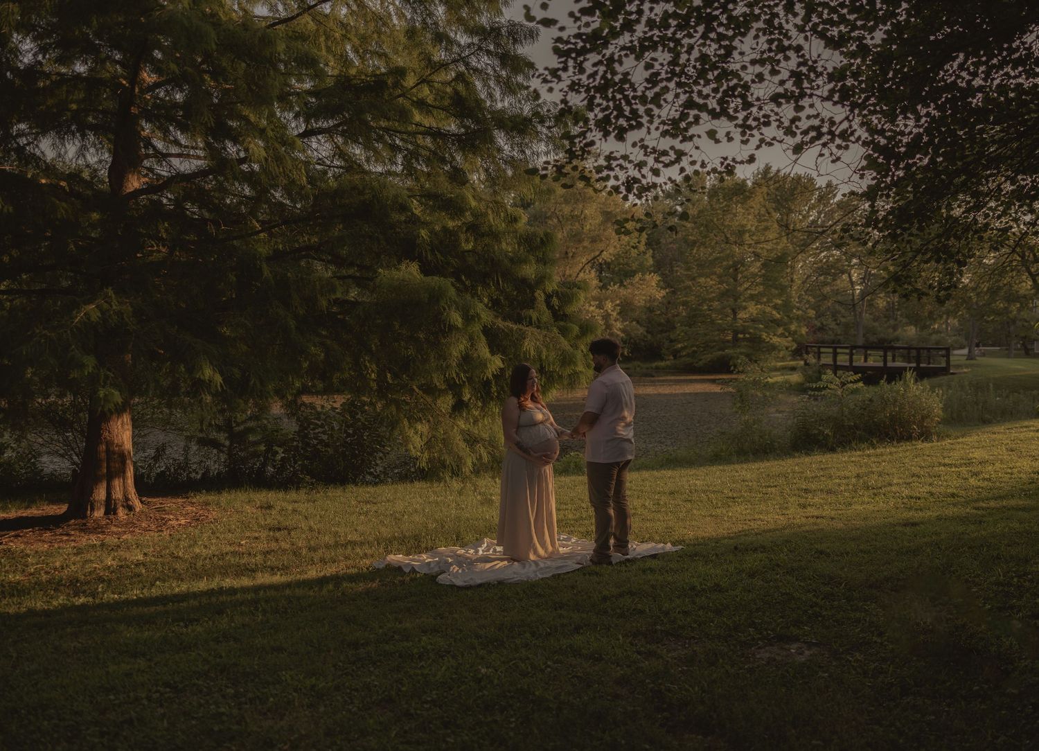 A serene outdoor ceremony taking place in a park during sunset.