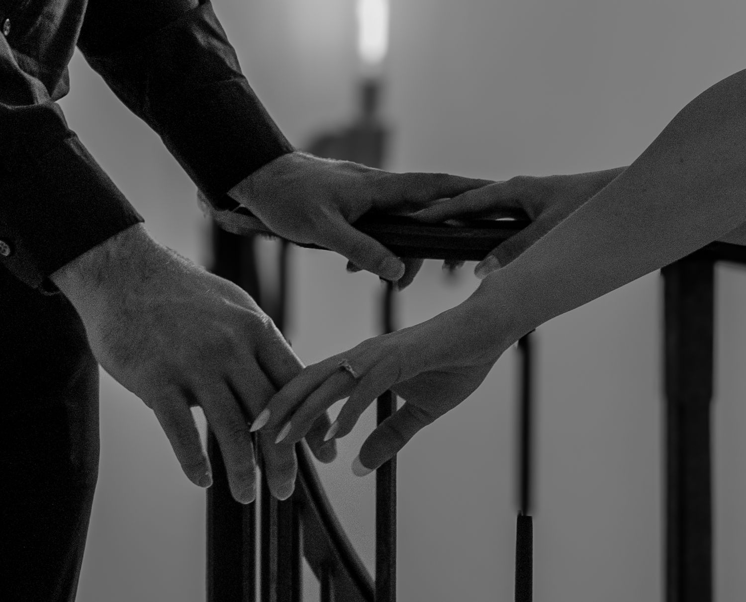 Close-up detail shots of hands touching and interacting in dramatic black and white.