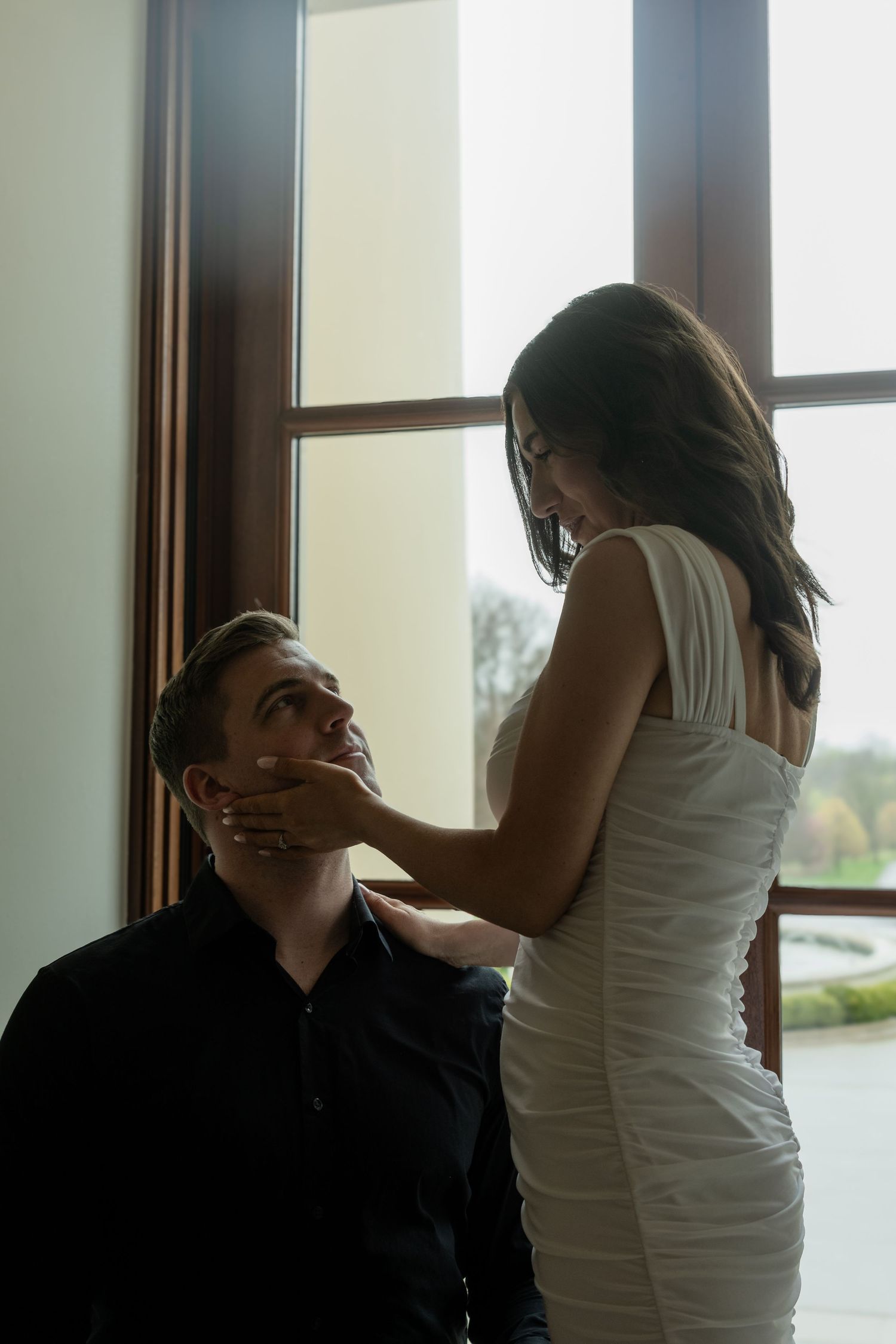 Intimate silhouettes by a window create a dramatic romantic photoshoot sequence.