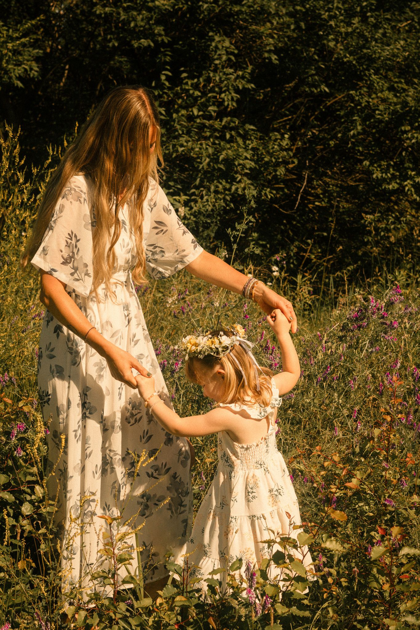 a mother and daughter embrace with love in an outdoor session utilizing a mirror prop for a story telling aspect
