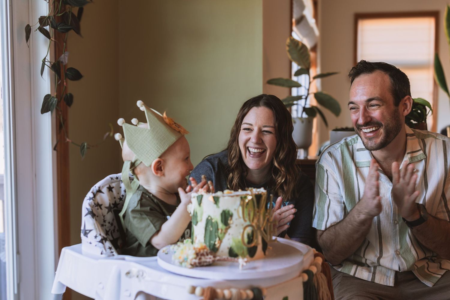 Several people seated at a dining table laugh joyfully together during a social gathering.