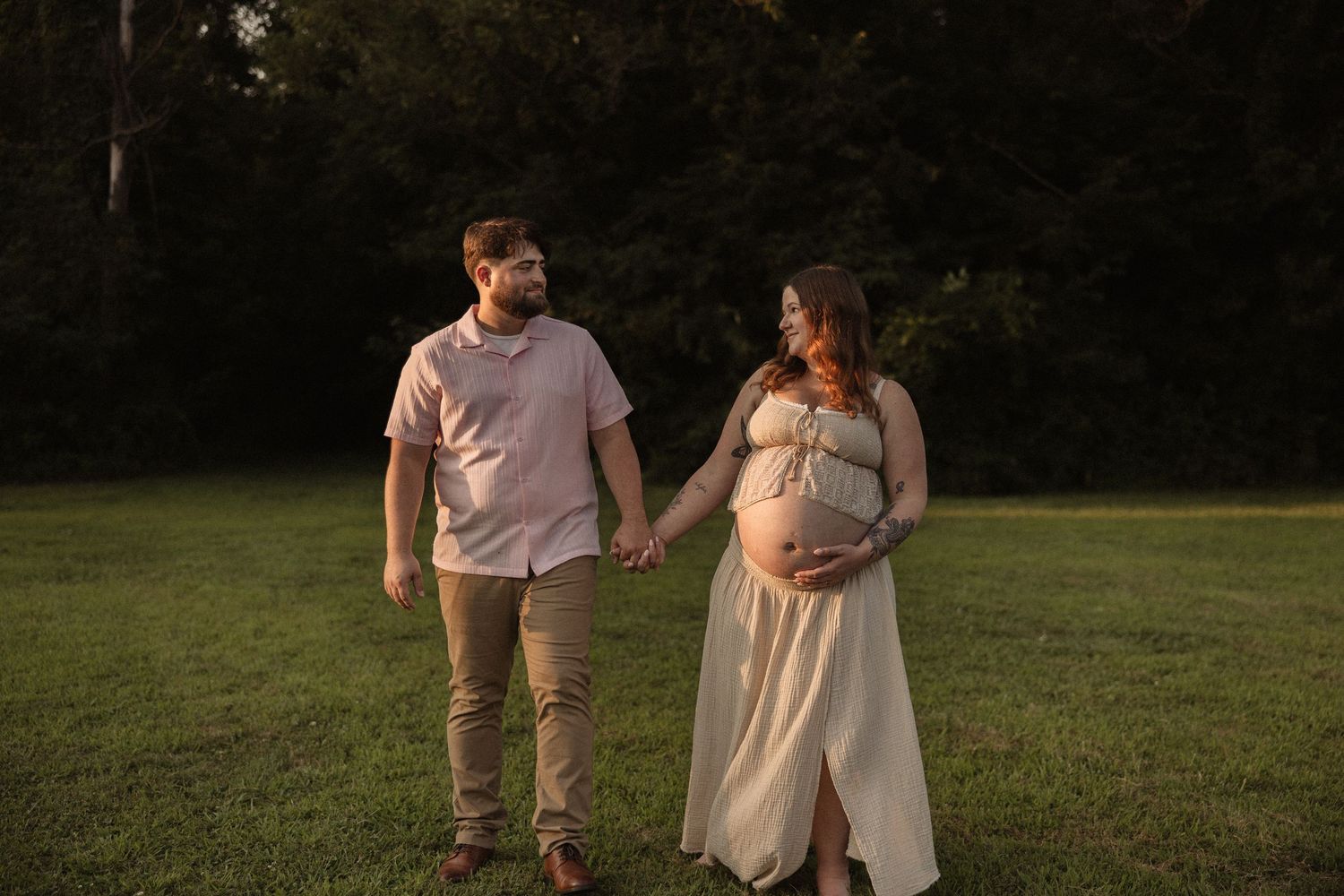 A couple strolls together through a scenic park during sunset.
