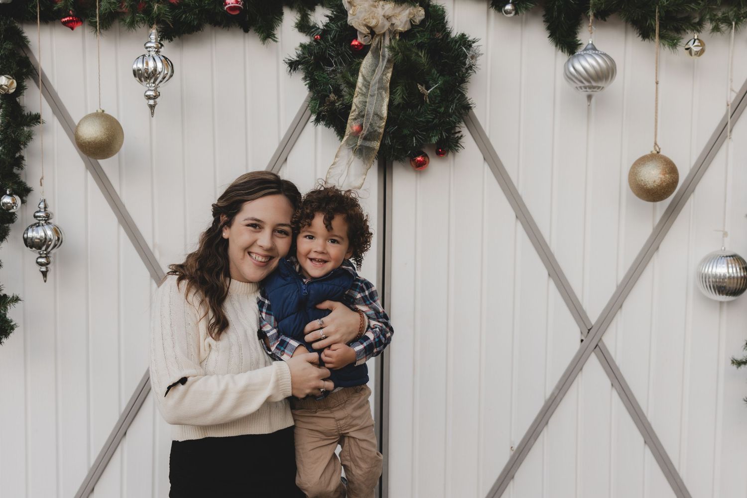 Festive holiday portraits with Christmas decorations and garland in background.