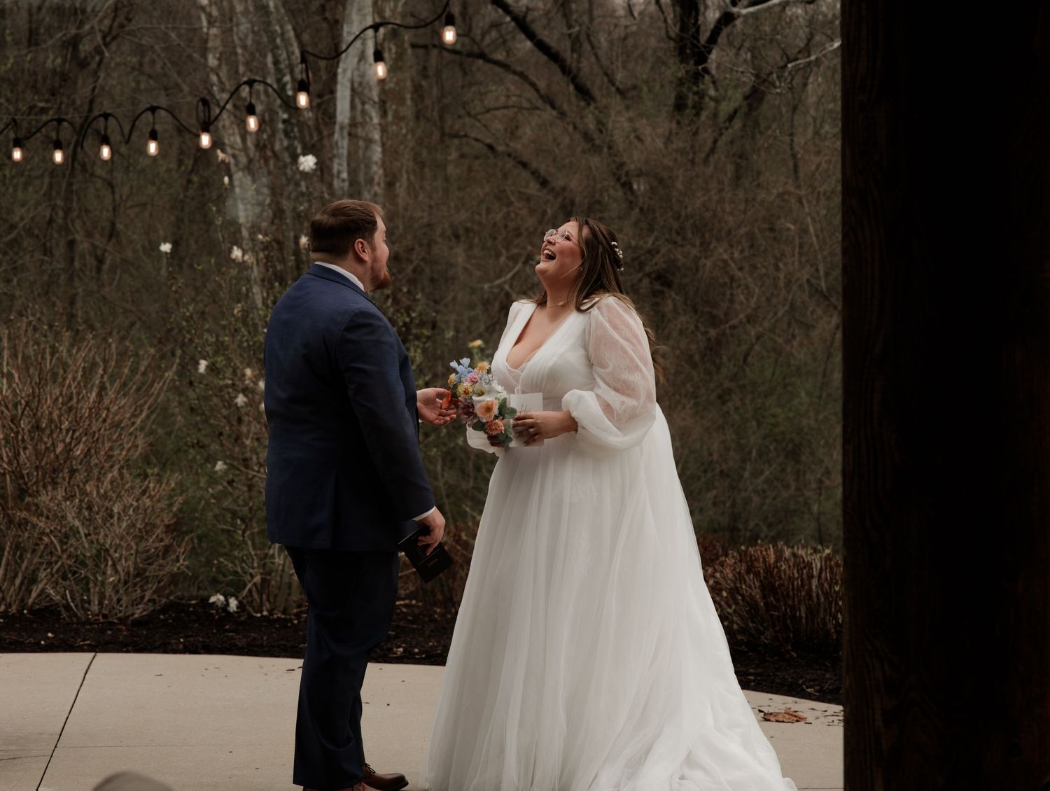 Winter wedding scene with string lights and tender moments between newlyweds.