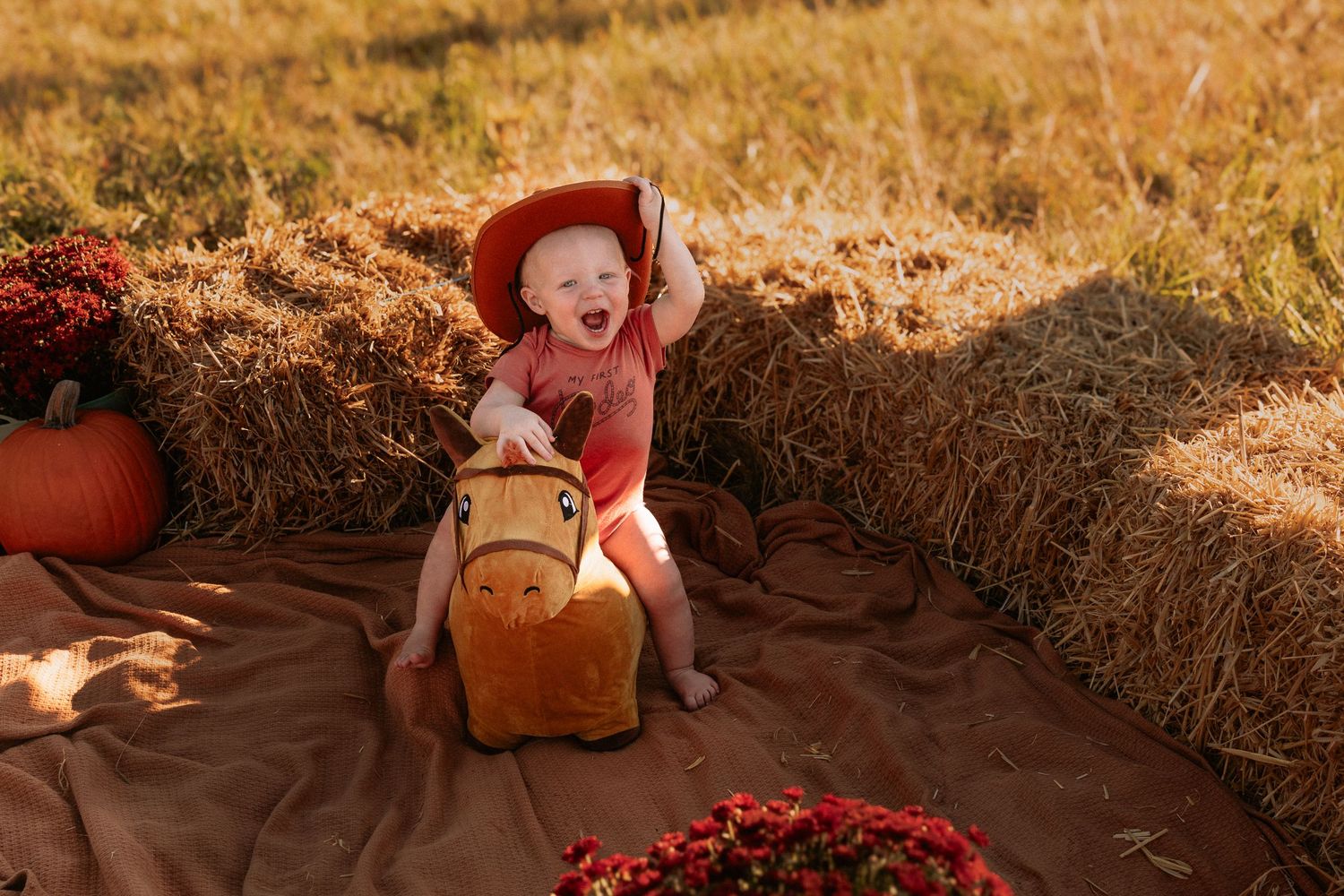 Family having fun around hay bales during autumn outdoor photoshoot.