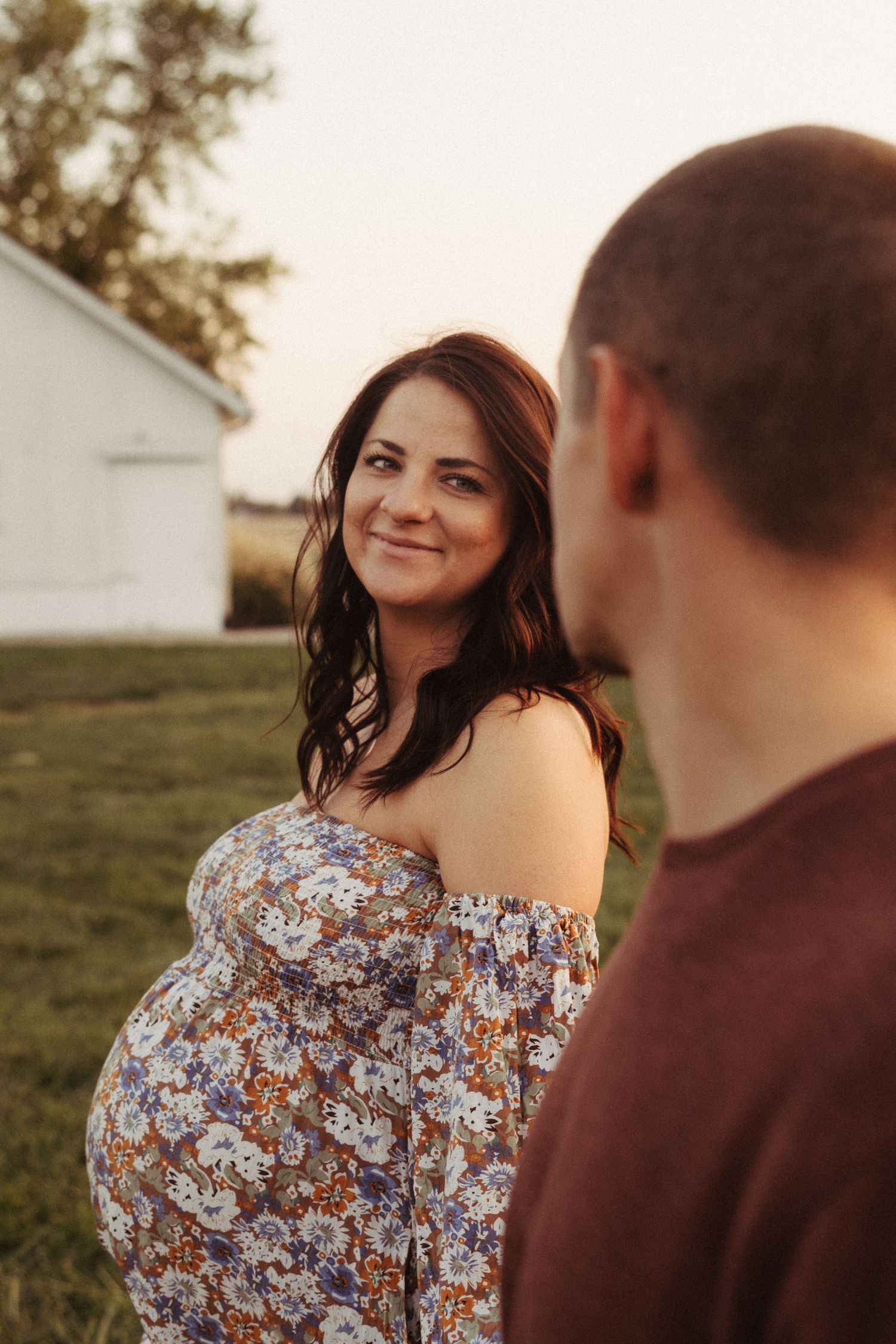 Couple shares romantic moment in a field during golden hour sunset.