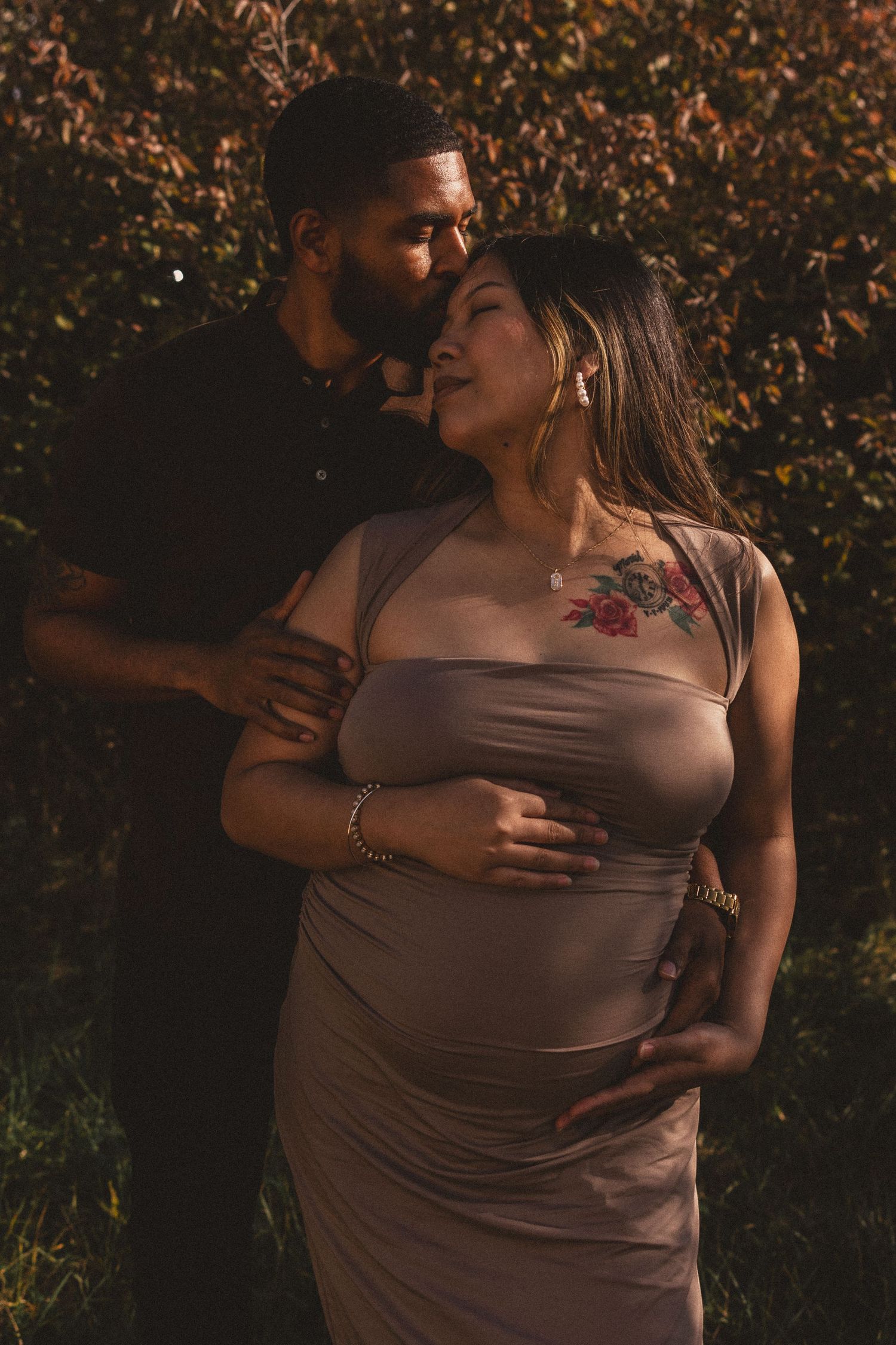 Intimate couple's photoshoot at sunset with warm lighting and natural poses.
