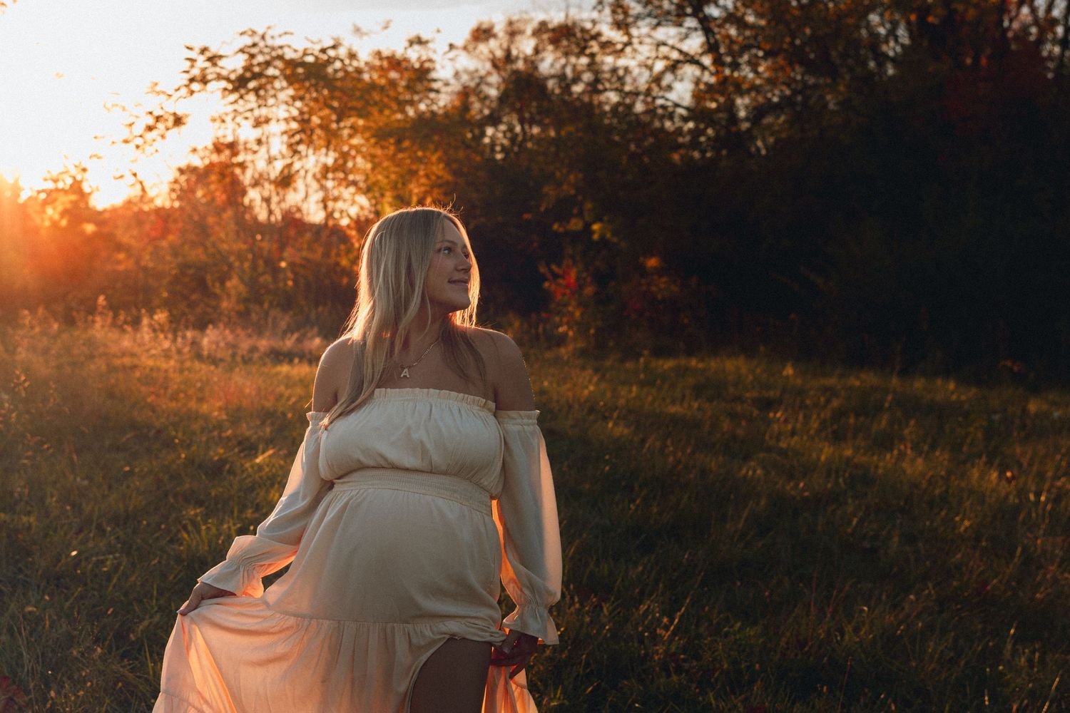 A couple shares an intimate moment on a hillside during sunset.