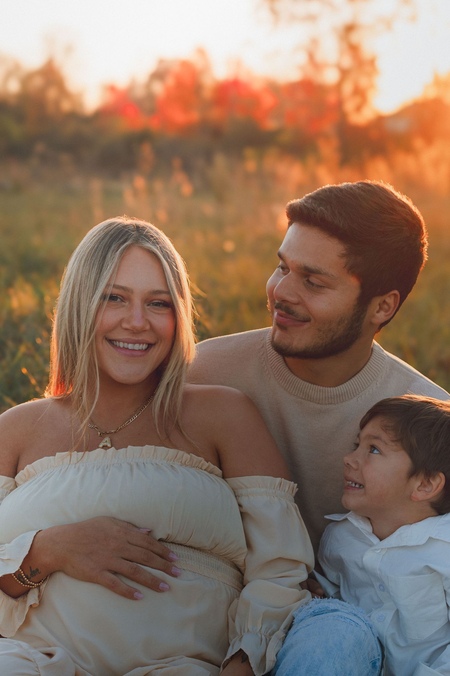 A family shares joyful moments together in a field during golden hour.