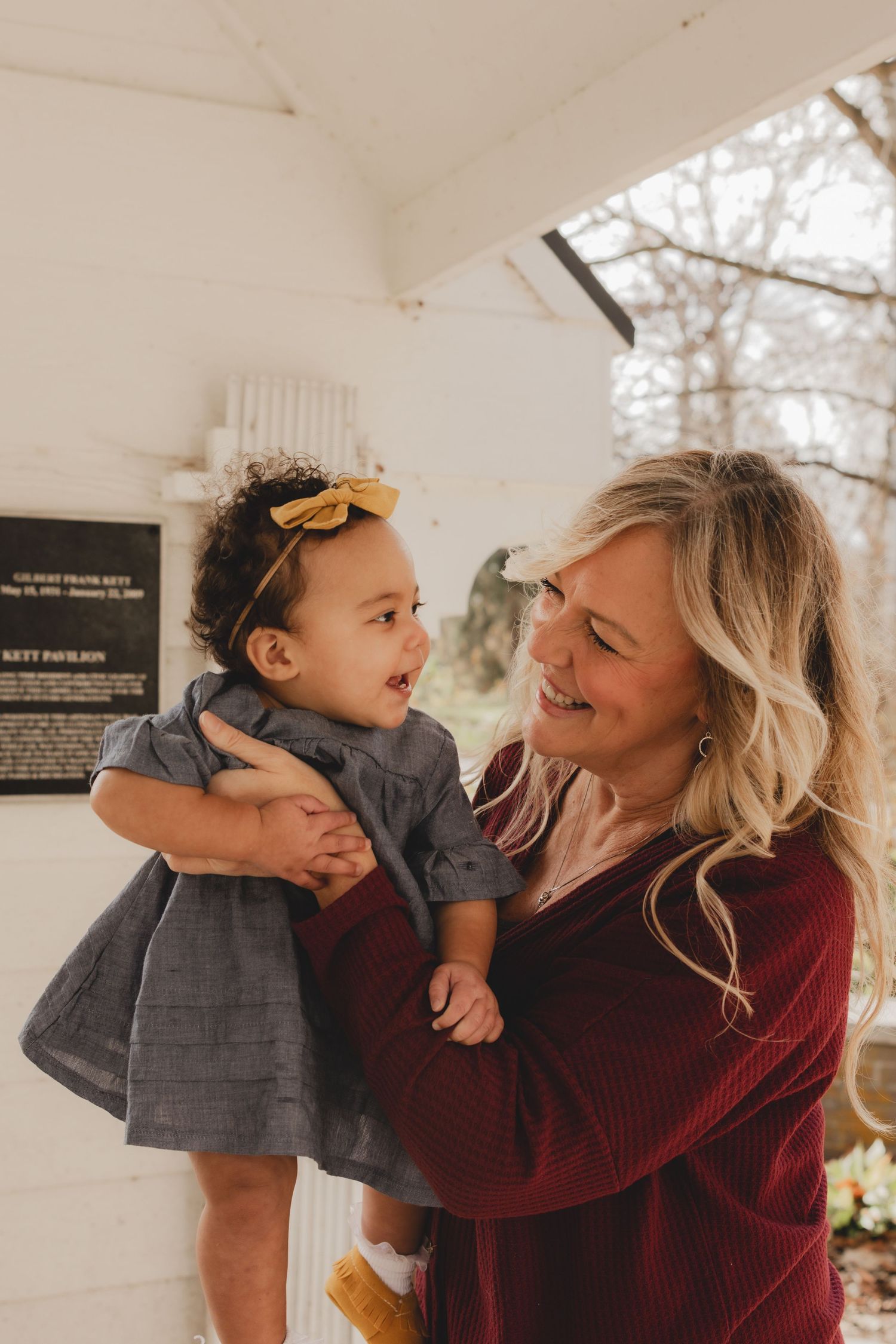 Sweet candid moment between parent and child in burgundy and grey outfits.