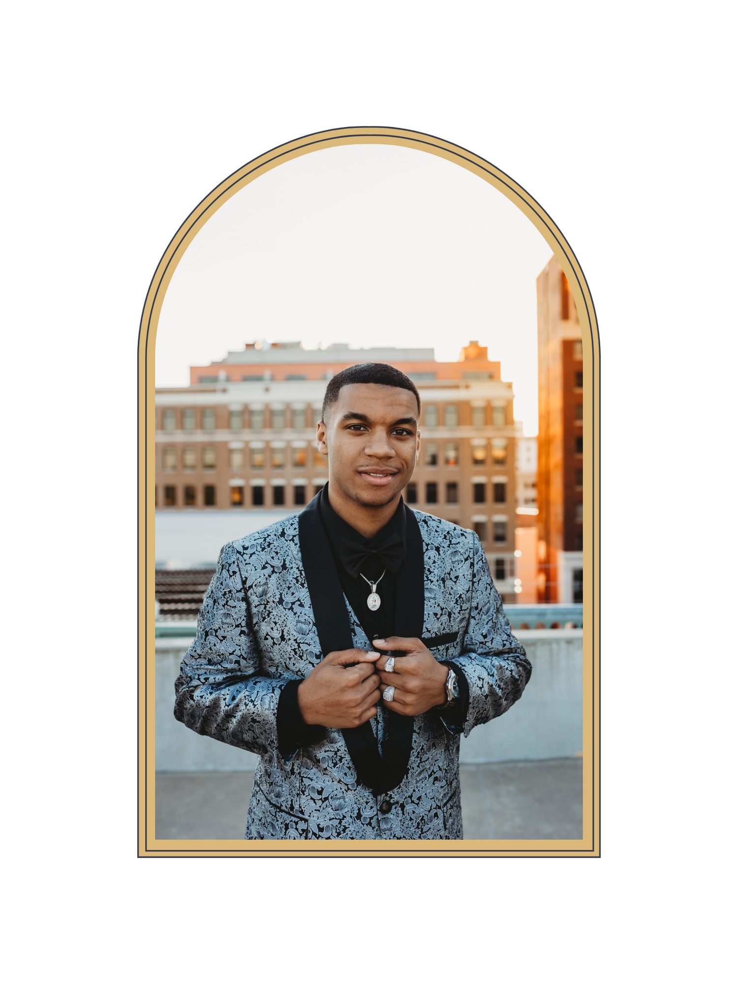A young man in a patterned blazer poses confidently in front of a city skyline at golden hour.