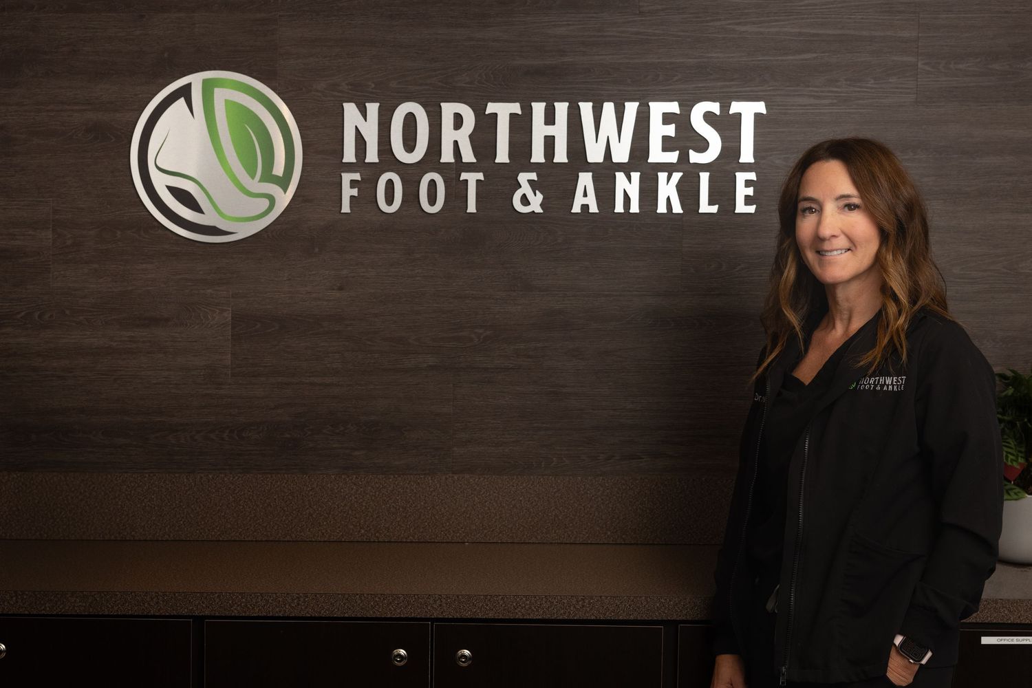 Northwest Foot & Ankle clinic signage on dark wood background.