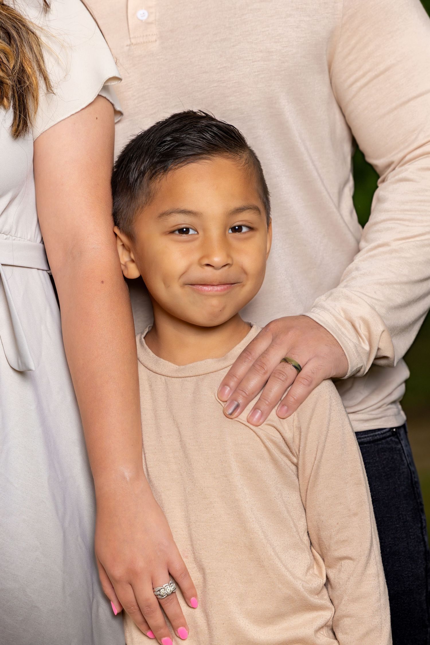 Studio portraits showing warm expressions against neutral background in beige tones.