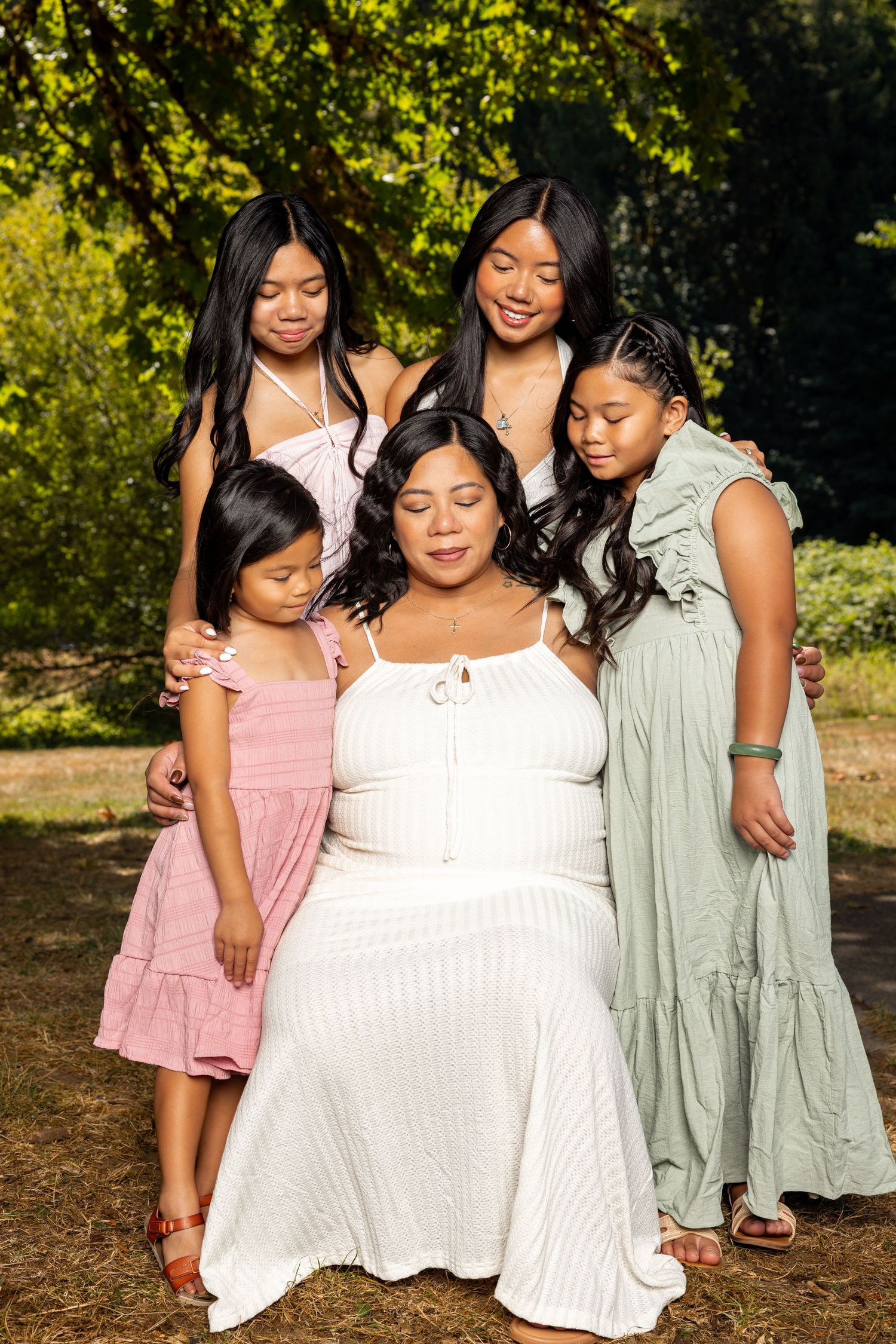 Group photo outdoors showing people in coordinated white and pastel dresses.
