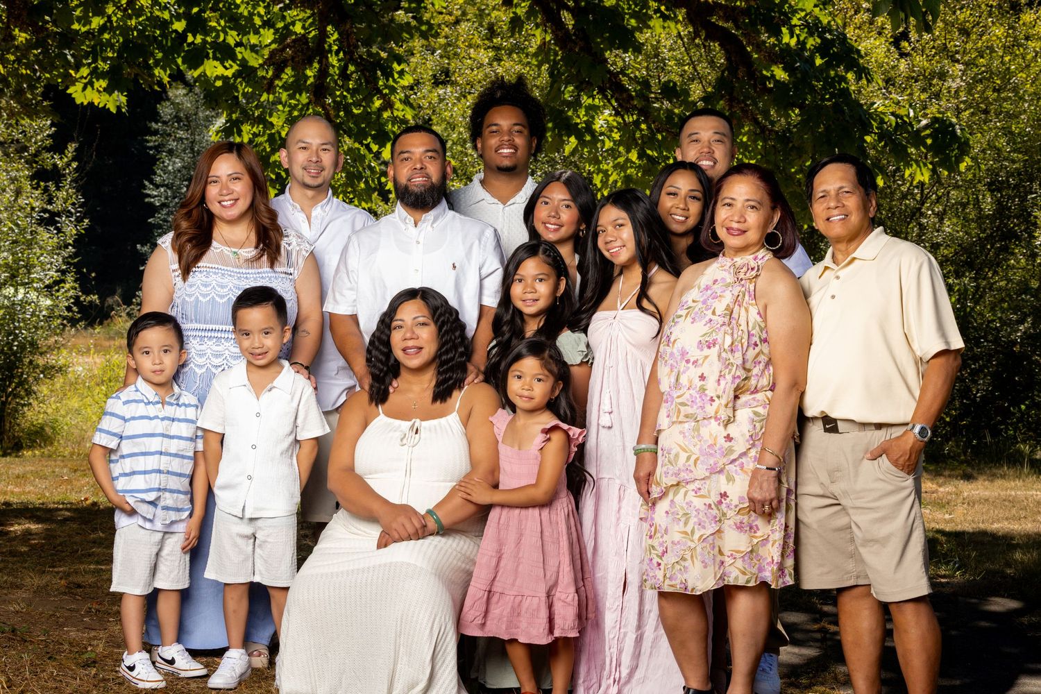 Large group portrait of families in coordinated outfits during golden hour.