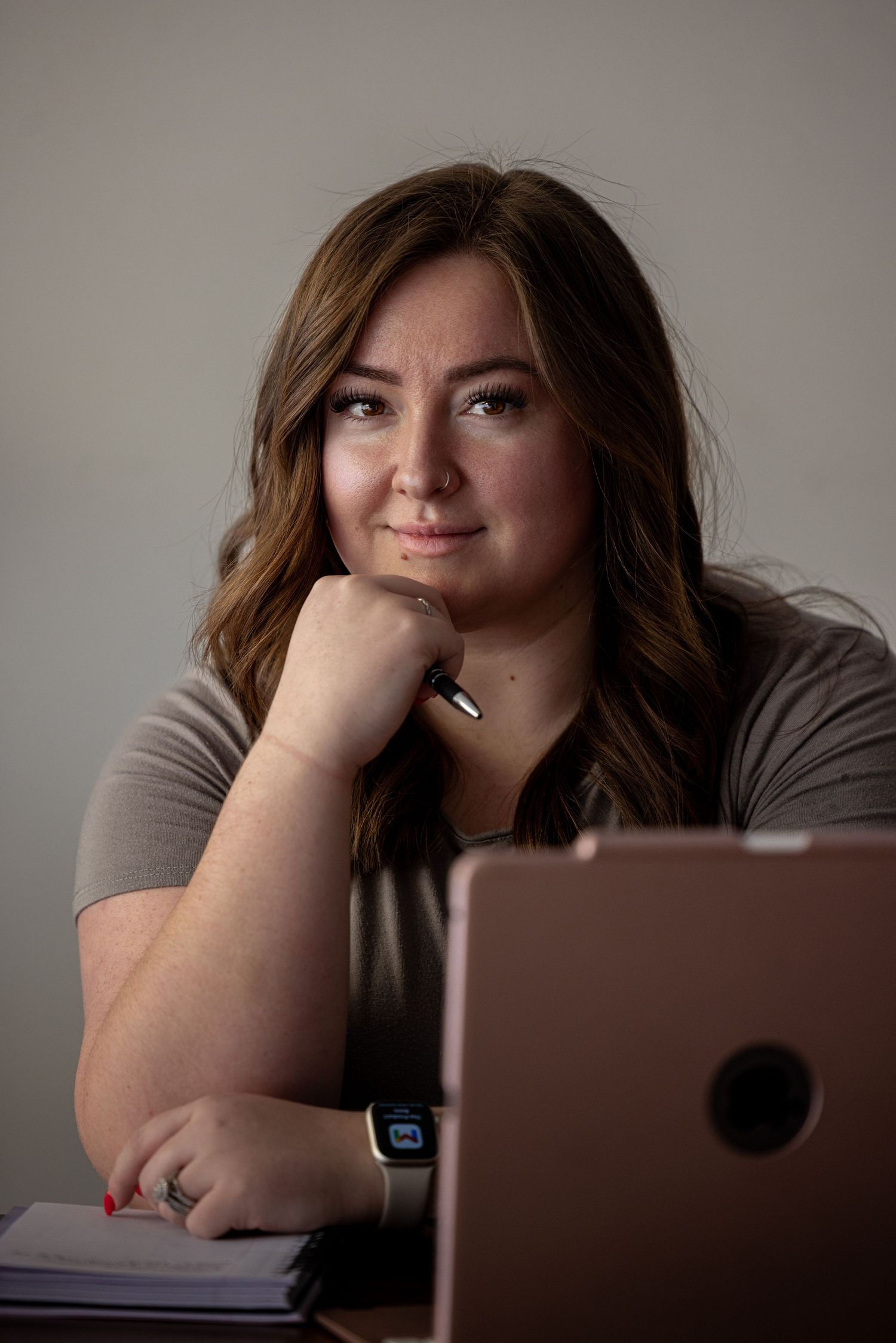 Person working on laptop while resting head on hand in contemplative poses.
