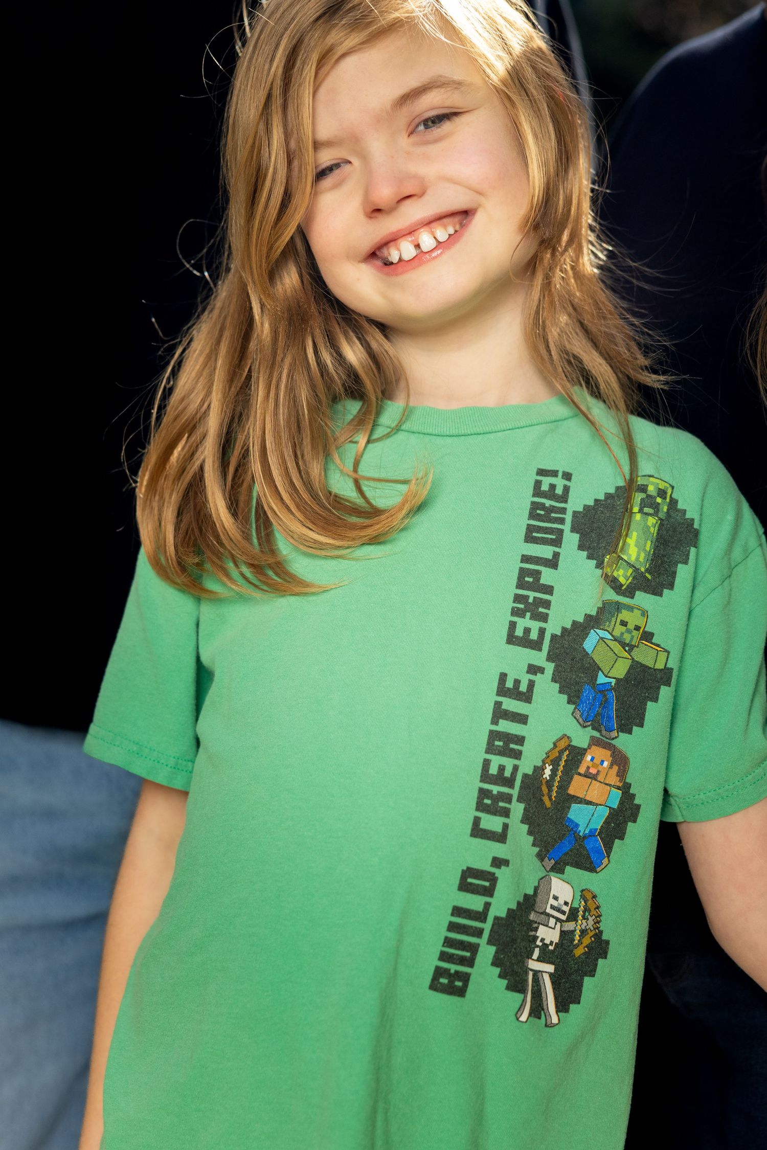 Child wearing green Minecraft t-shirt showing various playful expressions.