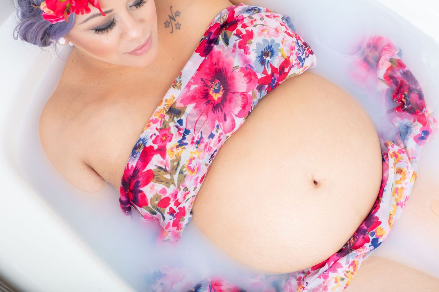 Artistic maternity photo showing floral pattern against white background.