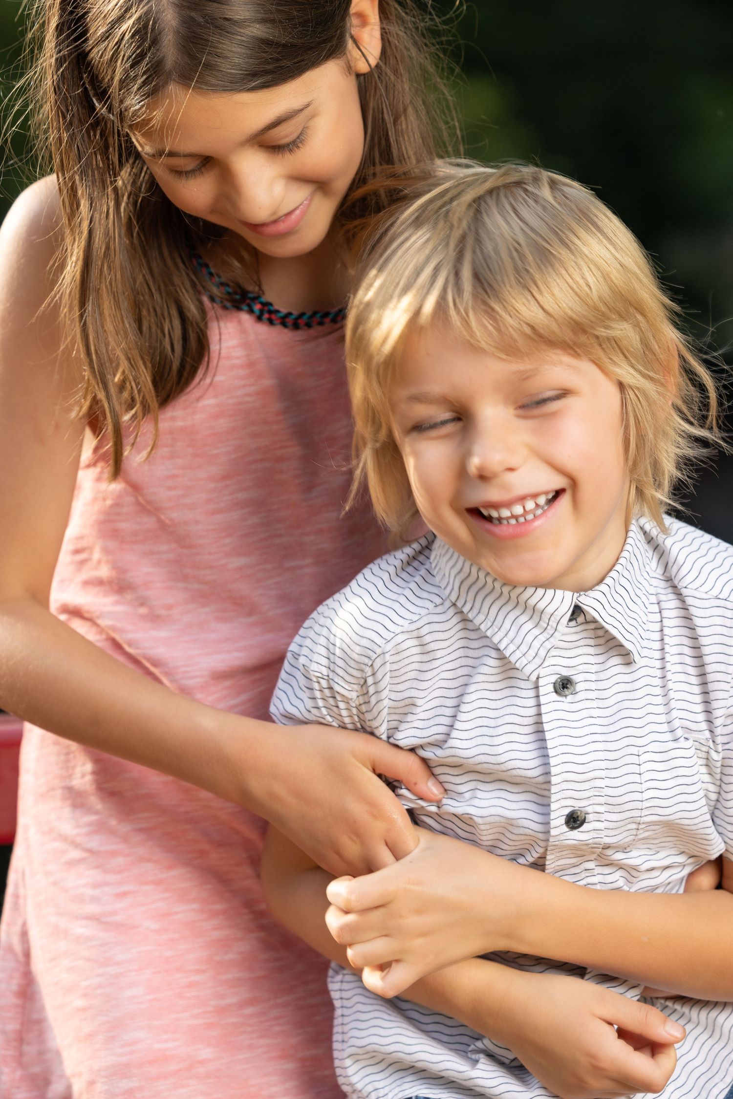 Two children sharing a playful moment together outdoors.