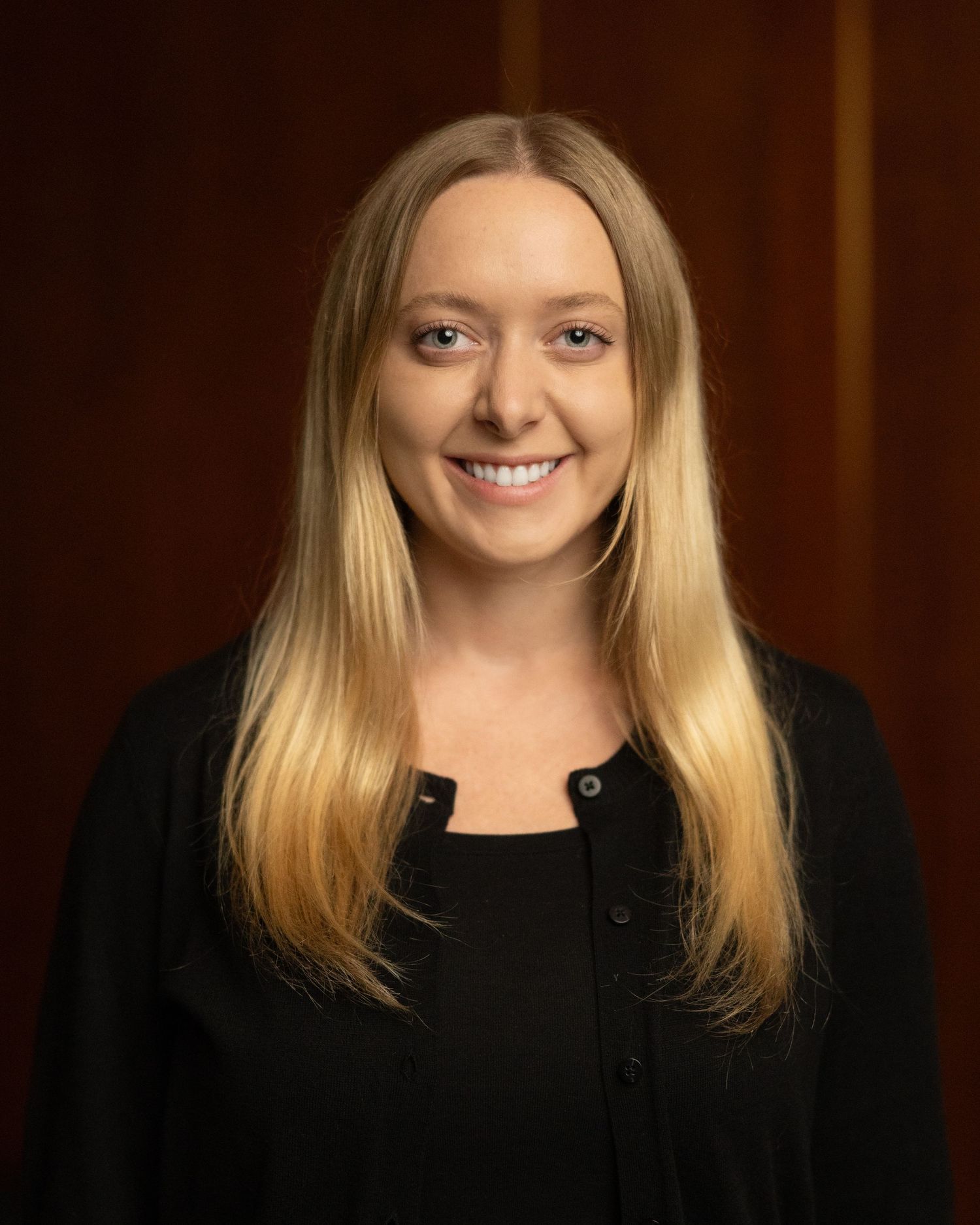 Professional portrait series in black attire against dark background.