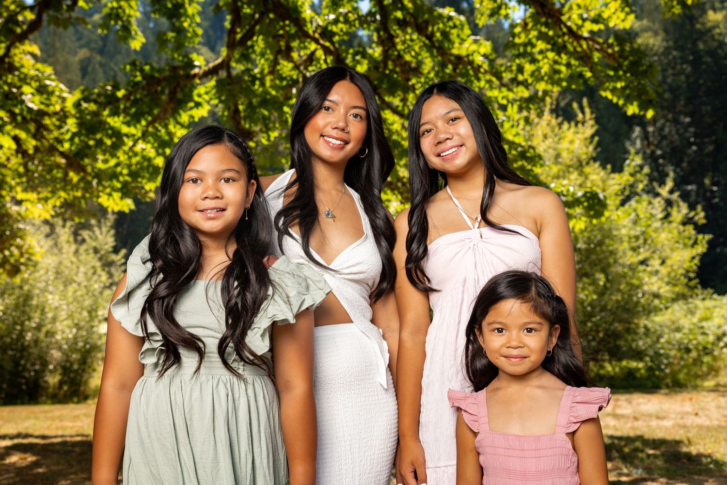 Candid family photos captured in a sunny park with lush greenery and golden lighting.