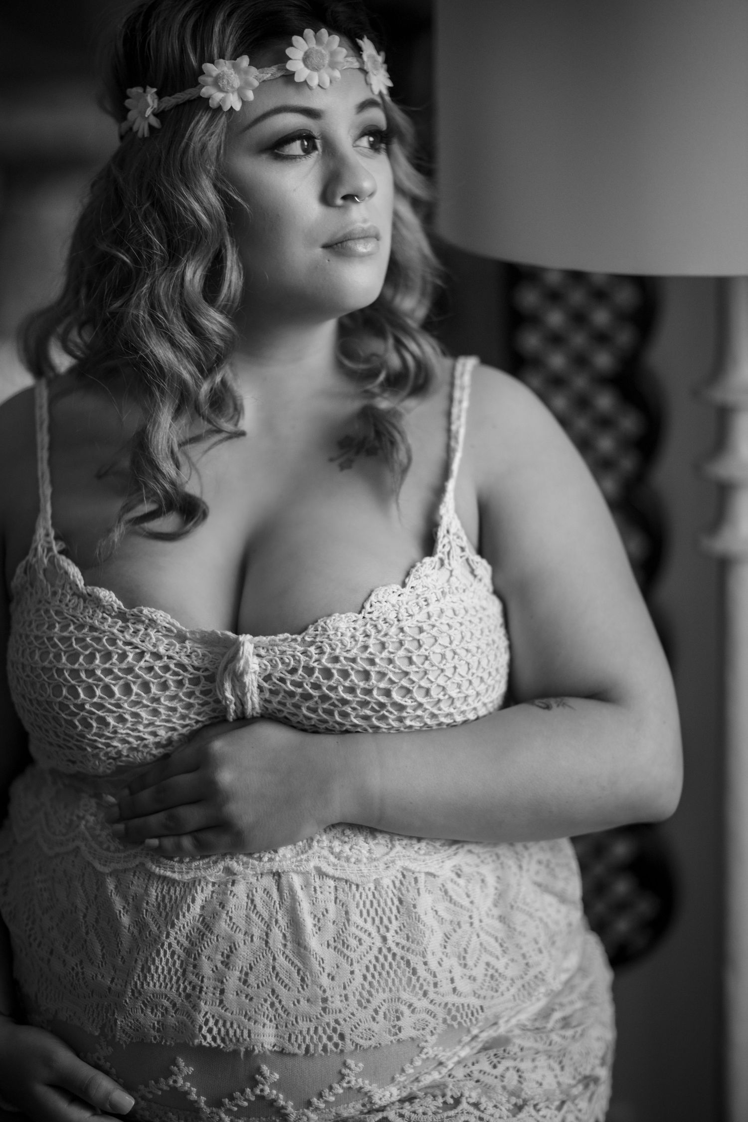 Black and white portrait of a person in lace dress with romantic styling and soft lighting.