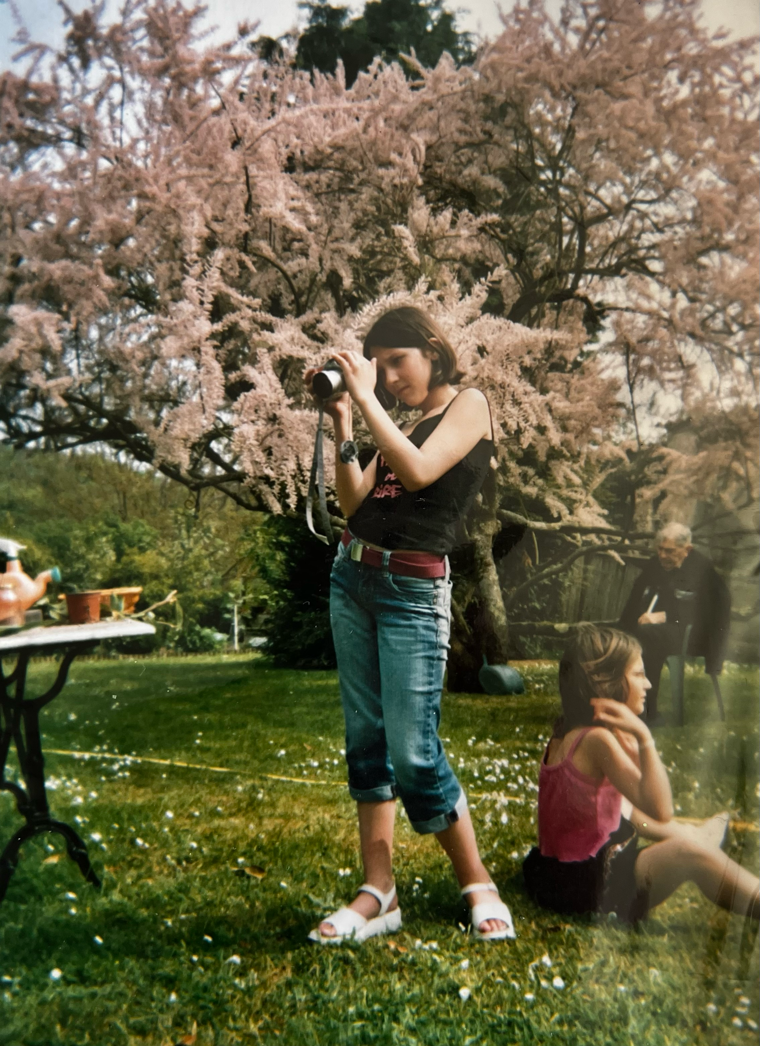 A sequence of jumping photos captures someone leaping through a blooming spring meadow with cherry blossom trees in the background.