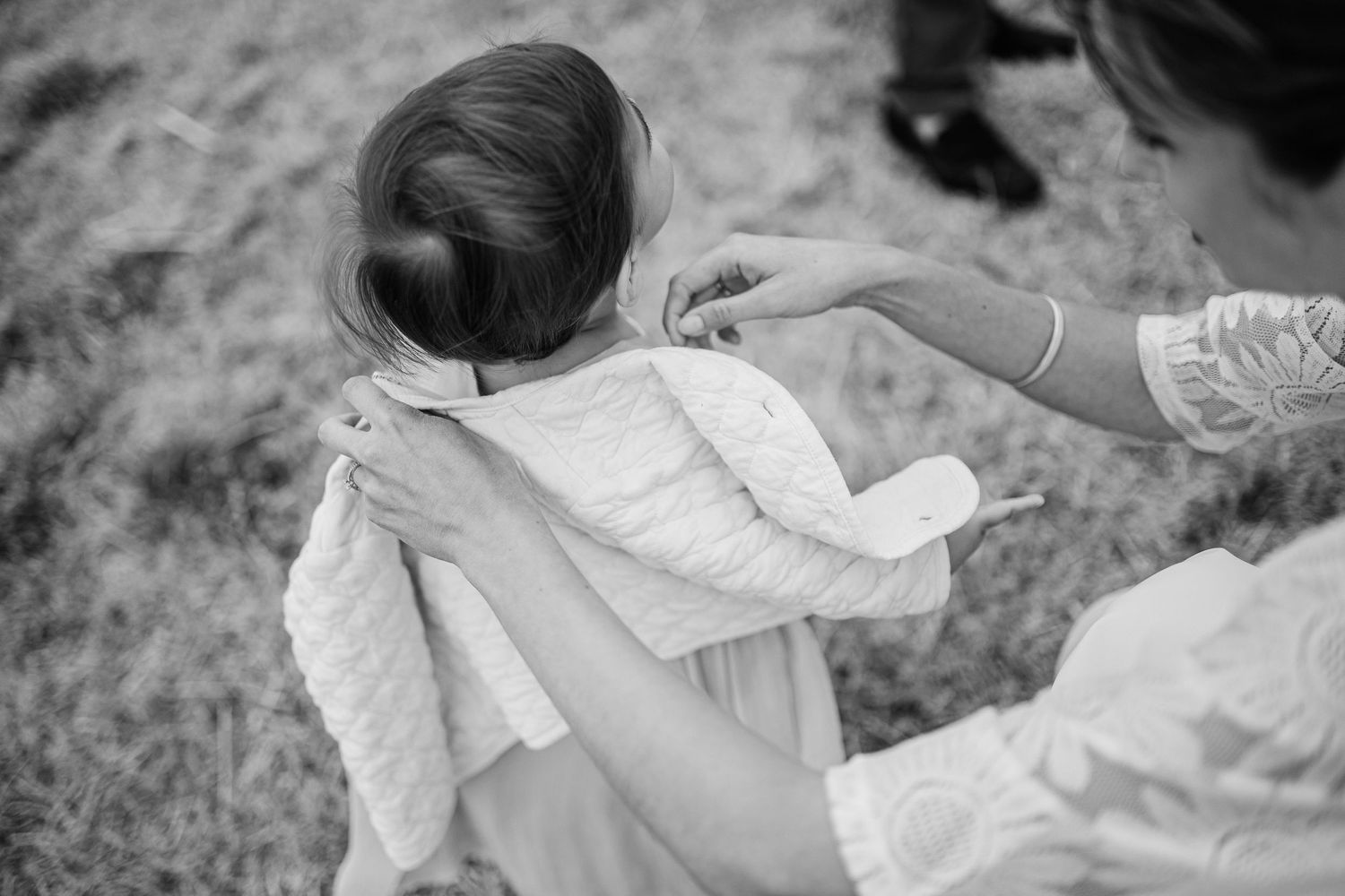 A series of black and white photos showing a person in a white dress sitting in a grassy outdoor setting.