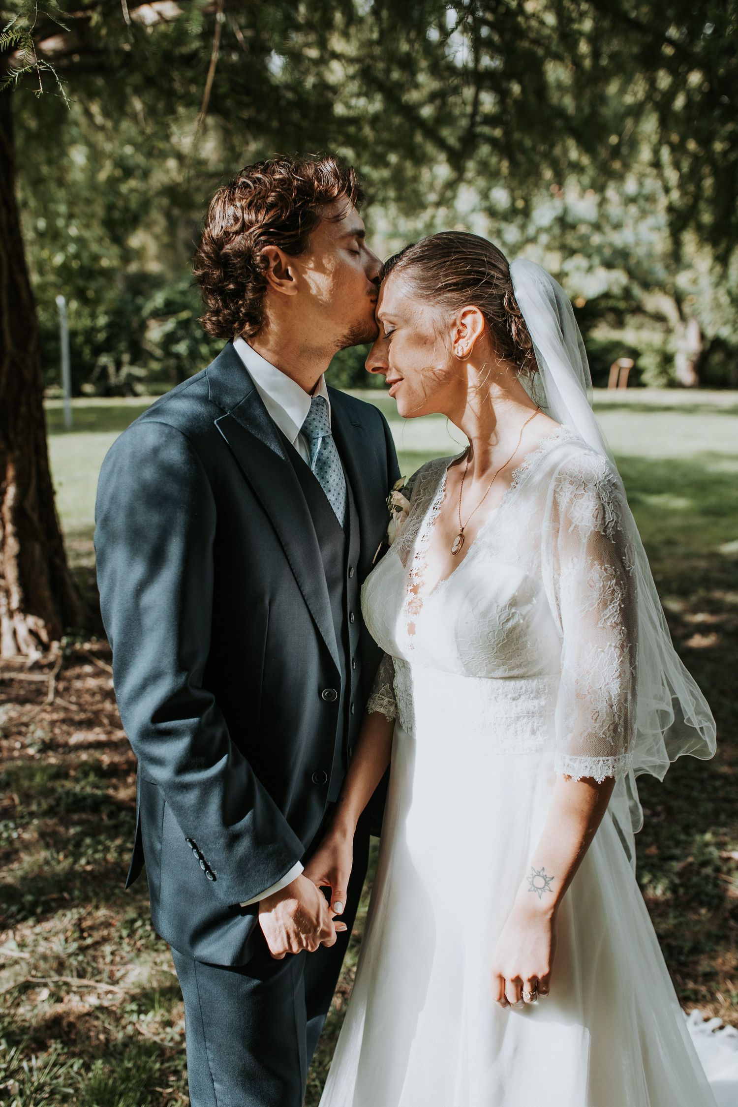 A bride and groom share intimate moments in an outdoor garden setting with natural lighting and greenery.